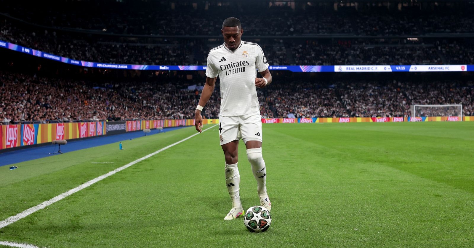 David Alaba steht mit eienm Ball am Rasen des Estadio Santiago Bernabeu Stadions