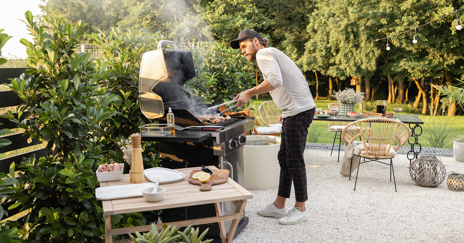 Mann grillt im Garten | Credit: iStock.com/RossHelen