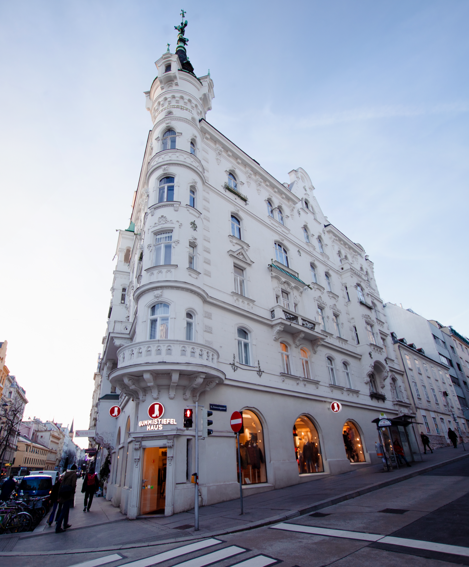 Blick auf ein weißes Eckhaus der Jahrhundertwende mit Erker und Dachreiter
