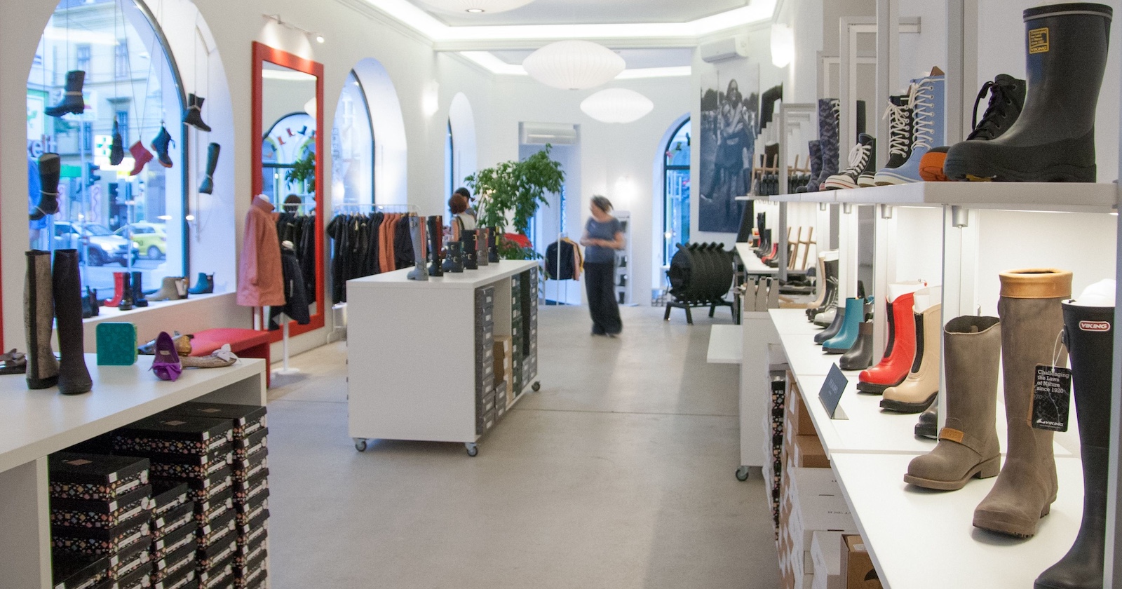 Geschäft mit großen Auslagenfenstern und vielen bunten Gummistiefeln auf den Stellflächen