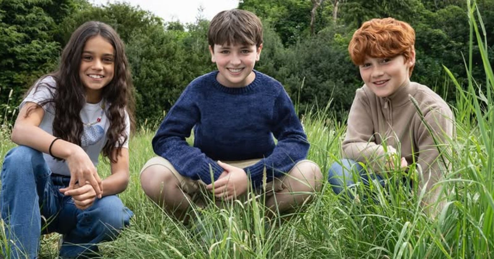 Die neuen Harry Potter-Hauptdarsteller knien im Gras: Arabella Stanton, Dominic McLaughlin and Alastair Stout