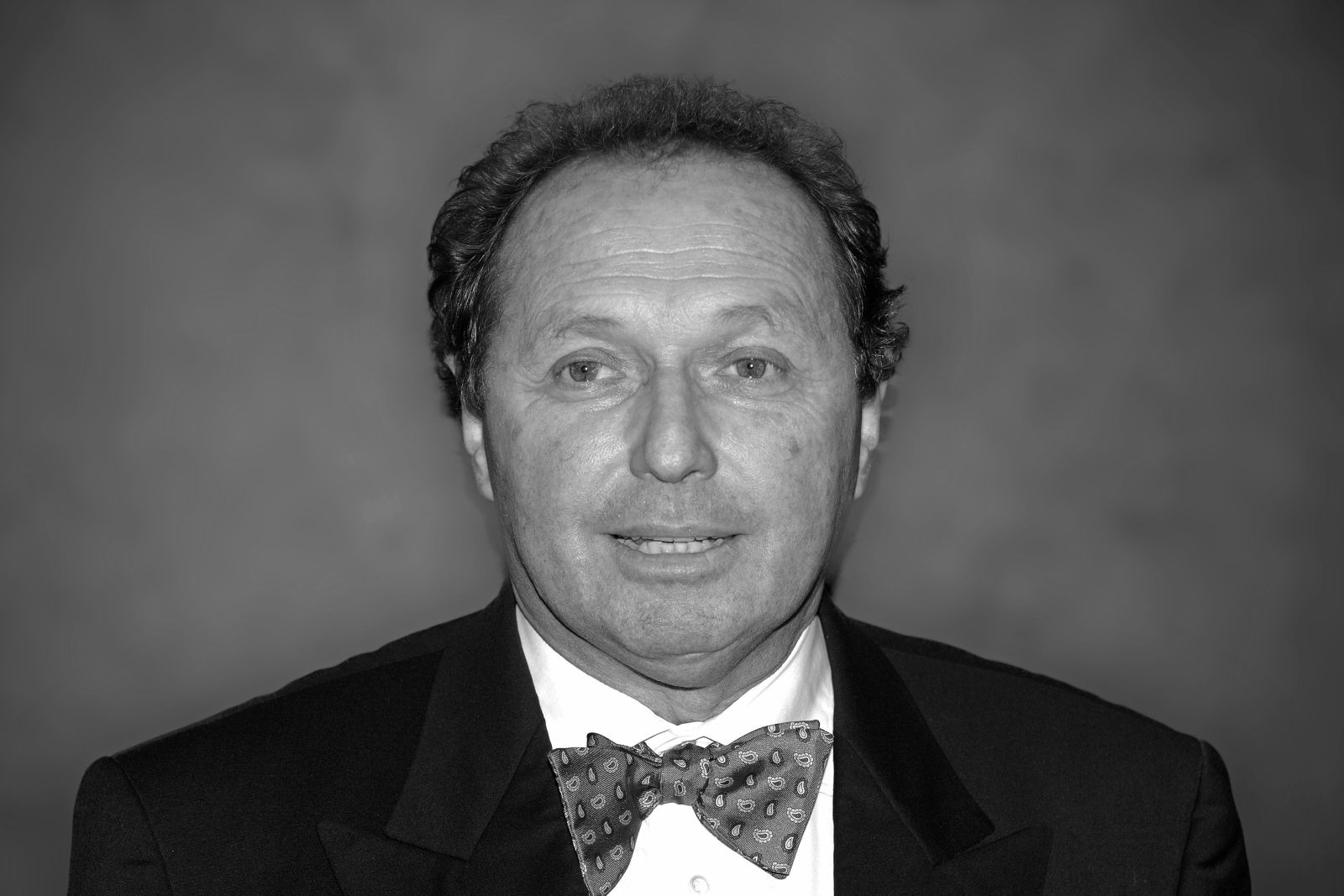 Formel-1-Rennfahrer Jochen Mass in formeller Kleidung mit Fliege, schwarz-weiß abgebildet