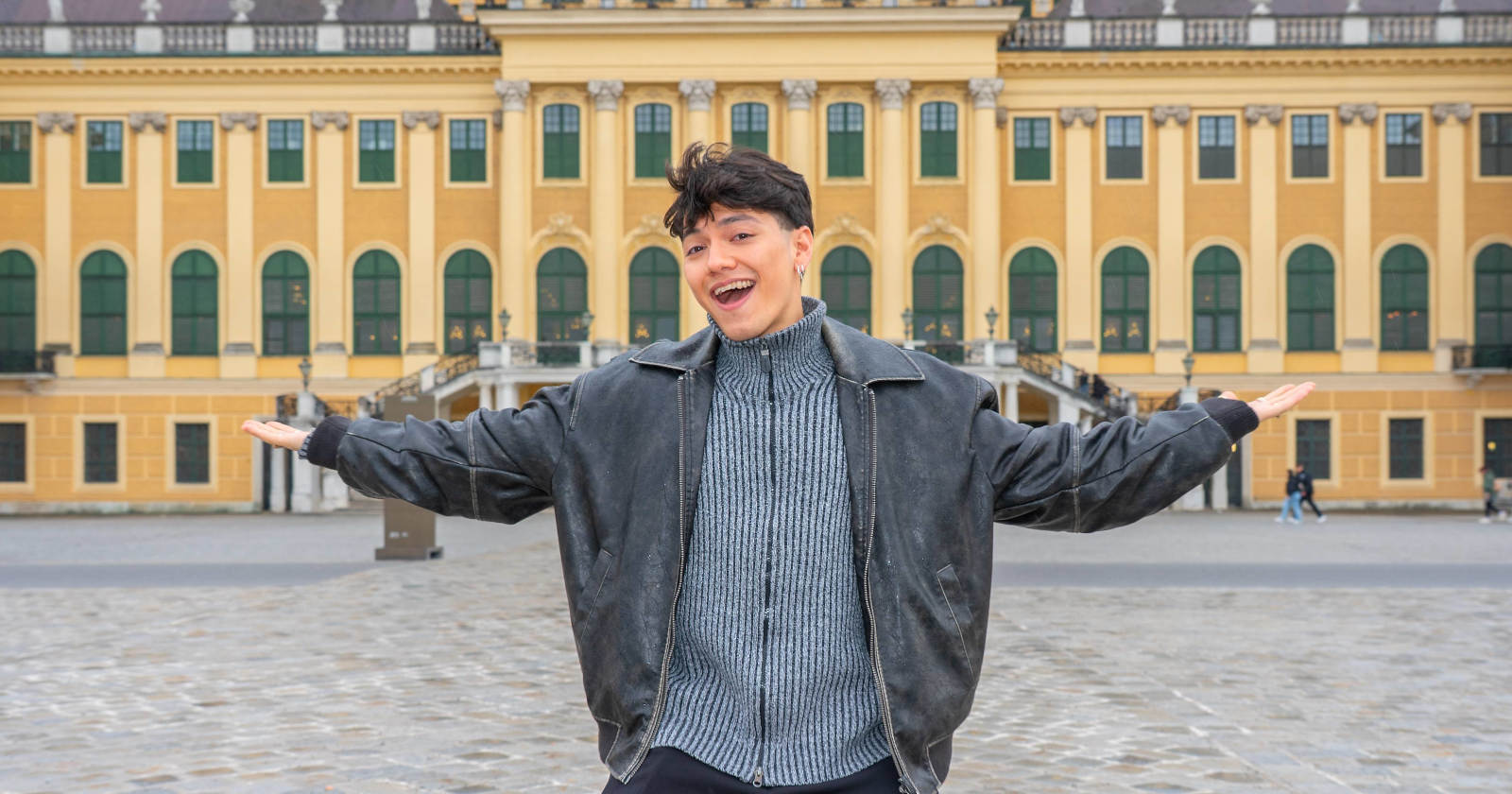 Ein Mann steht vor einem gelben Schloss