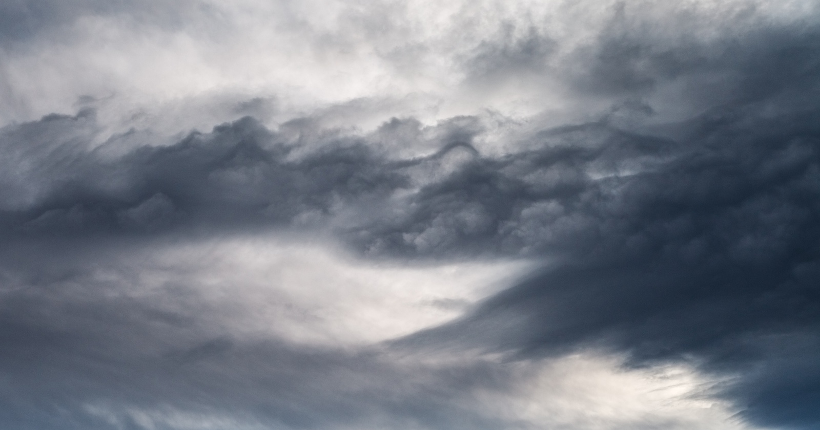 Bedrohlich wirkende, dunkle Gewitterwolken am Himmel als Vorboten einer Kaltfront mit starkem Regen und Abkühlung in Österreich.
