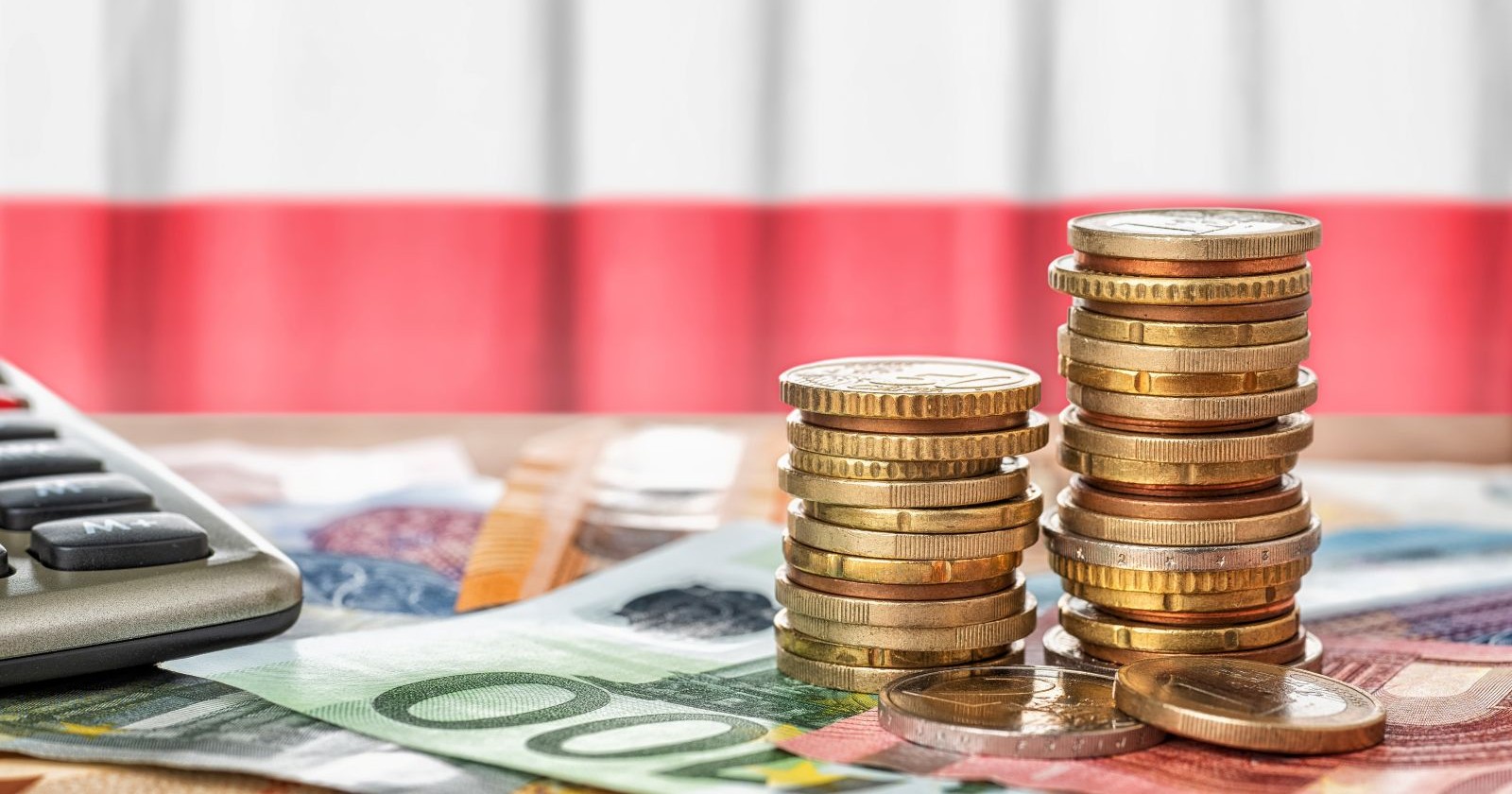 Geld und ein Taschenrechner vor einer Österreich-Flagge