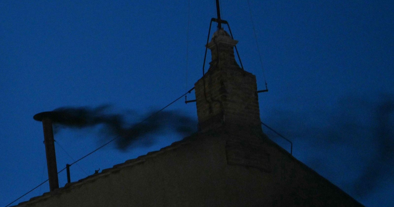 Schwarzer Rauch steigt aus dem Schornstein der Sixtinischen Kapelle bei Dunkelheit – Zeichen für eine erfolglose Wahl im Konklave zur Papstwahl 2025.