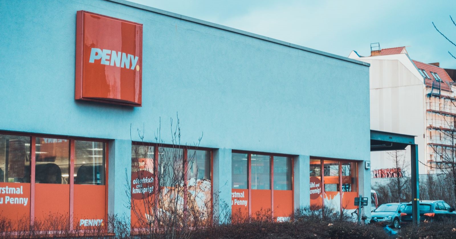 Filiale von Penny mit neuem Logo aus weißer Schrift auf rotem Grund mit gelben Punkt: Penny ändert Namen und Logo im Rahmen eines umfassenden Markenrelaunches.