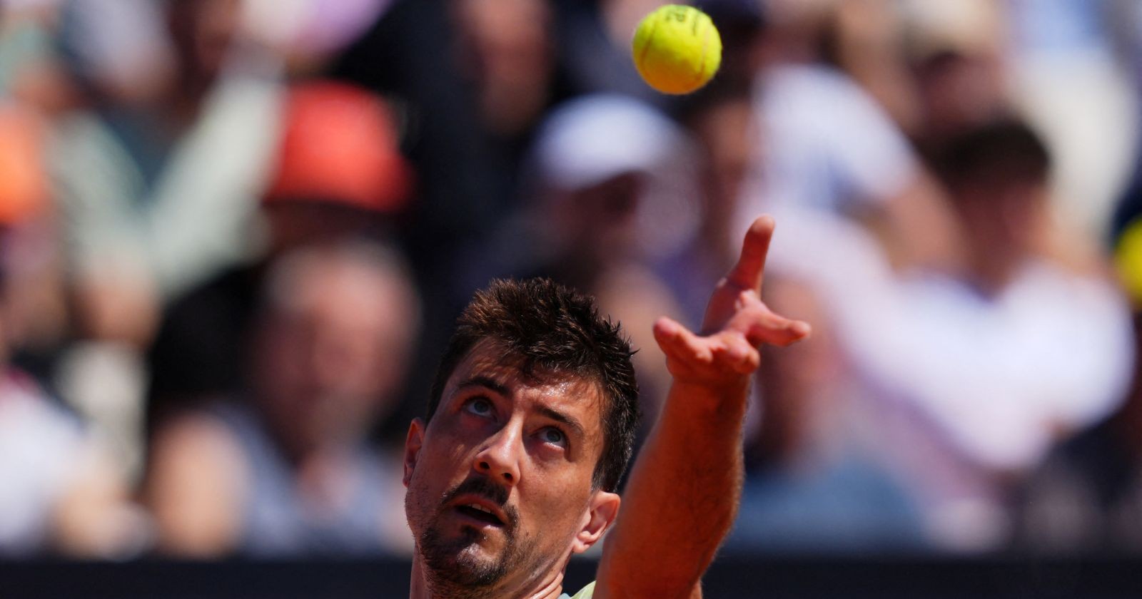 Sebastian Ofner wirft während eines Tennismatches den Ball in die Höhe zum Aufschlag.