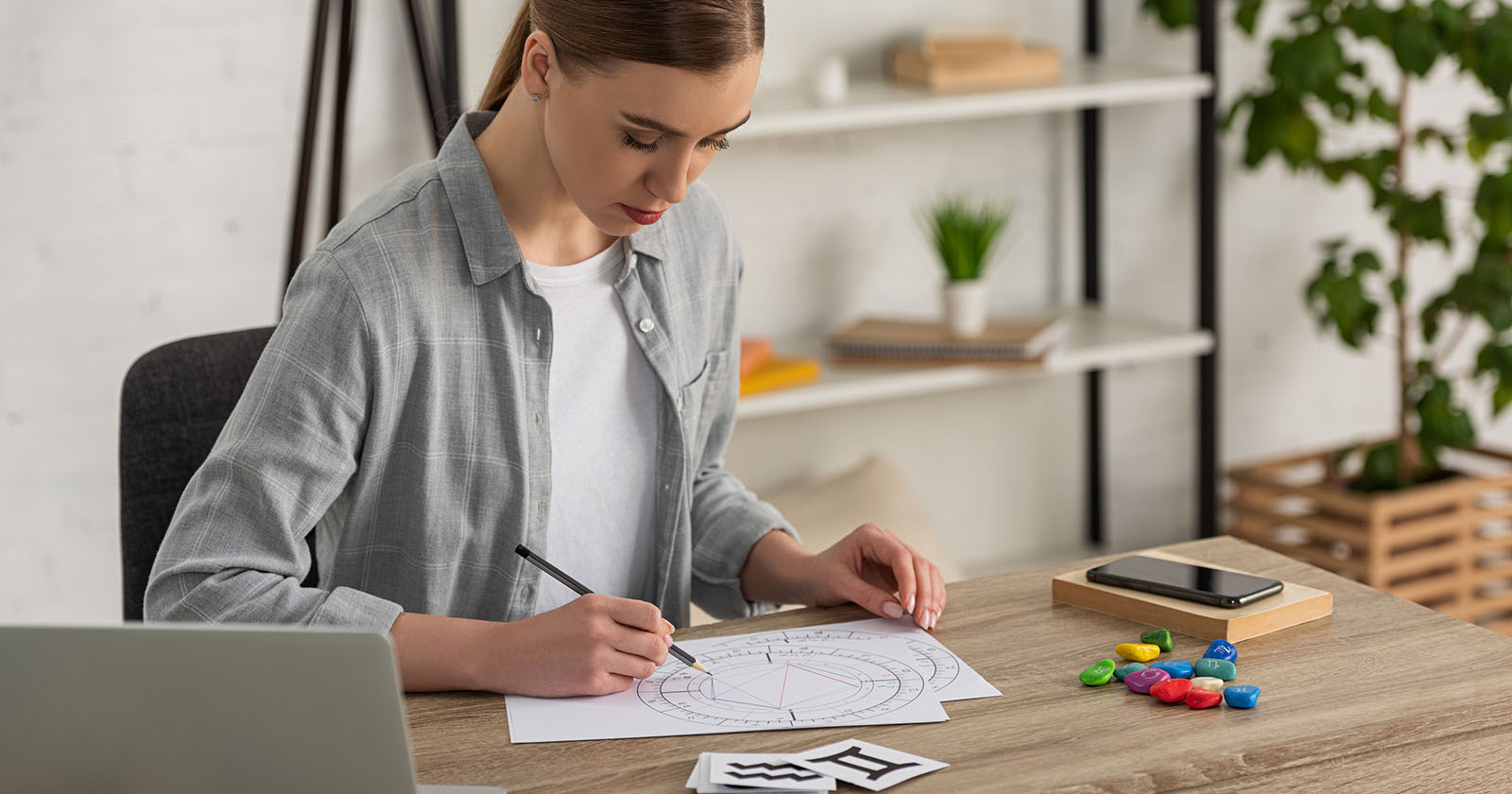 Frau sitzt an einem Tisch | Credit: iStock.com/LightFieldStudios
