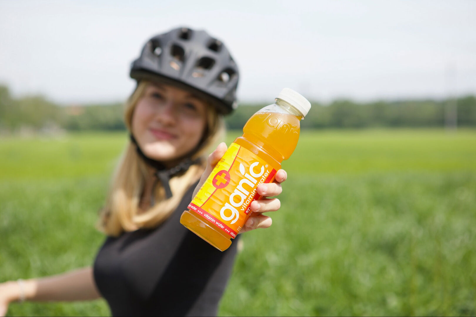 Junge Radfahrerin mit Getränkeflasche in der Hand | Credit: premium-drinks &amp; more