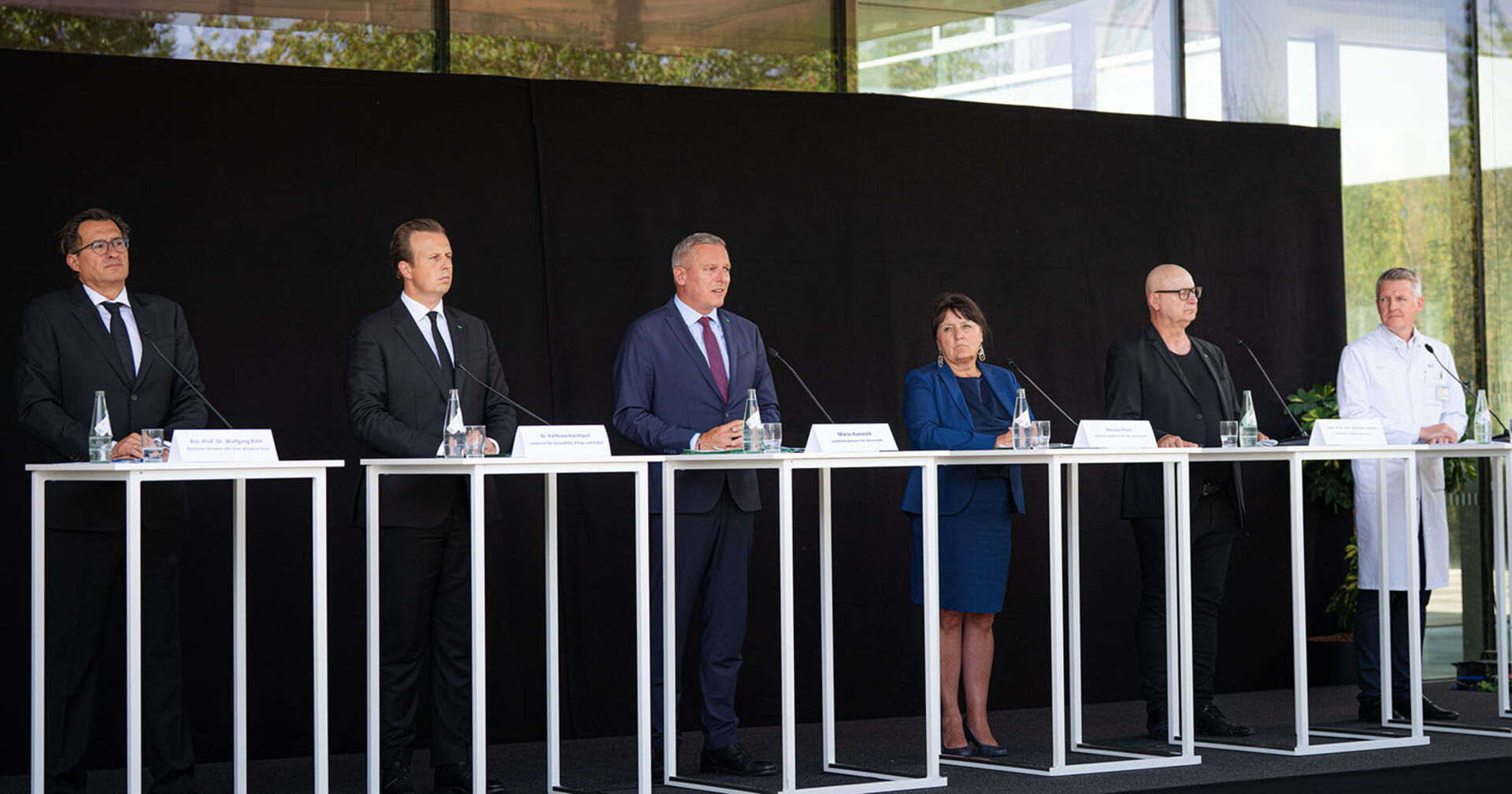 Gruppe von Menschen stehend hinter Podium