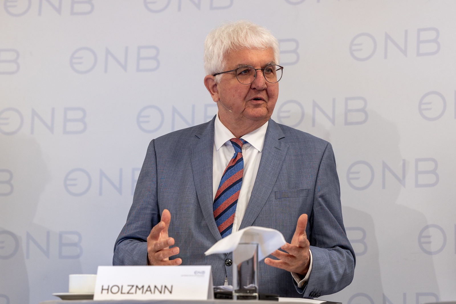 Porträt am Panel mit Logo-Aufsteller im Hintergrund