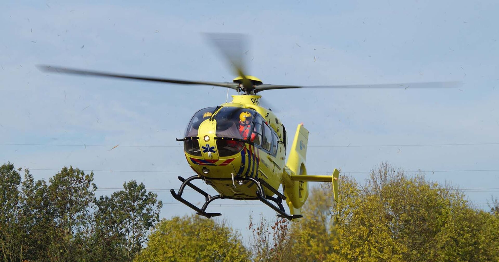 Ein gelber Rettungshubschrauber setzt zur Landung an