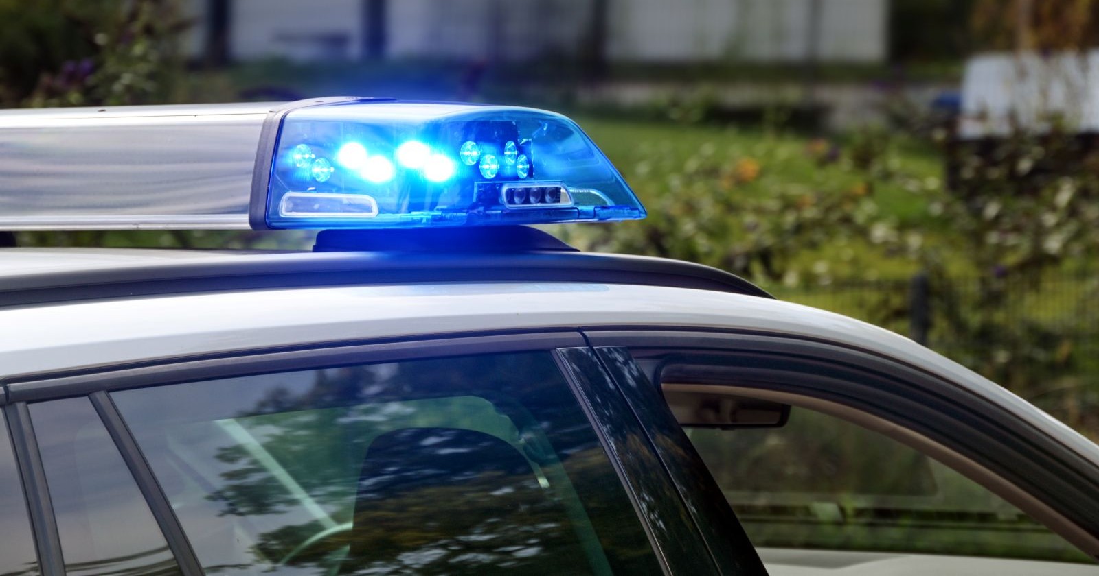 Blinkende blaue Lichter an einem Polizeiauto im Dienst, Teil des Fahrzeugs