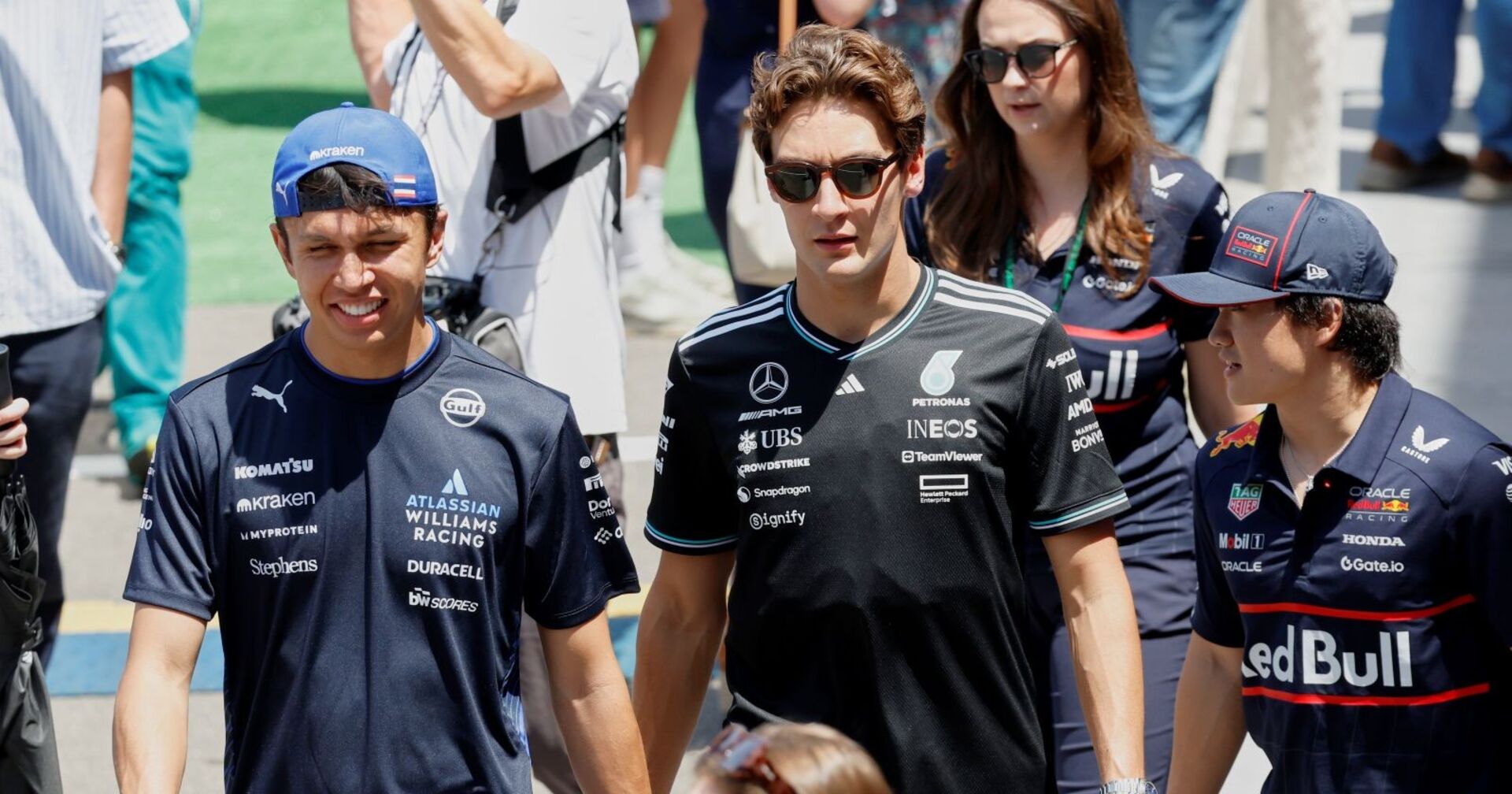Alexander Albon, George Russell und Yuki Tsunoda marschieren durch das Paddock in Barcelona