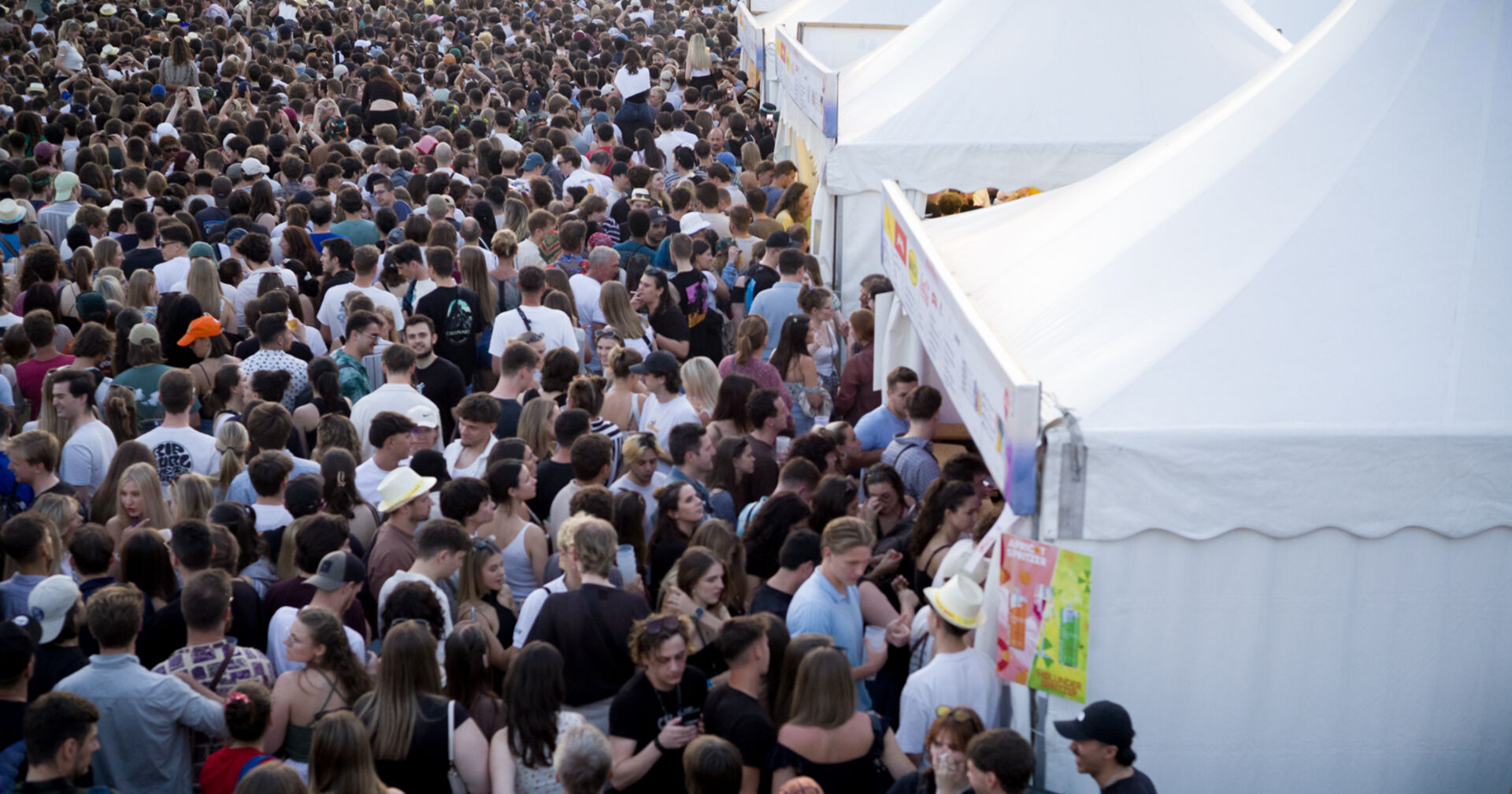 Beuscherinnen und Besucher des Donauinselfestes vor einem Getränkezelt