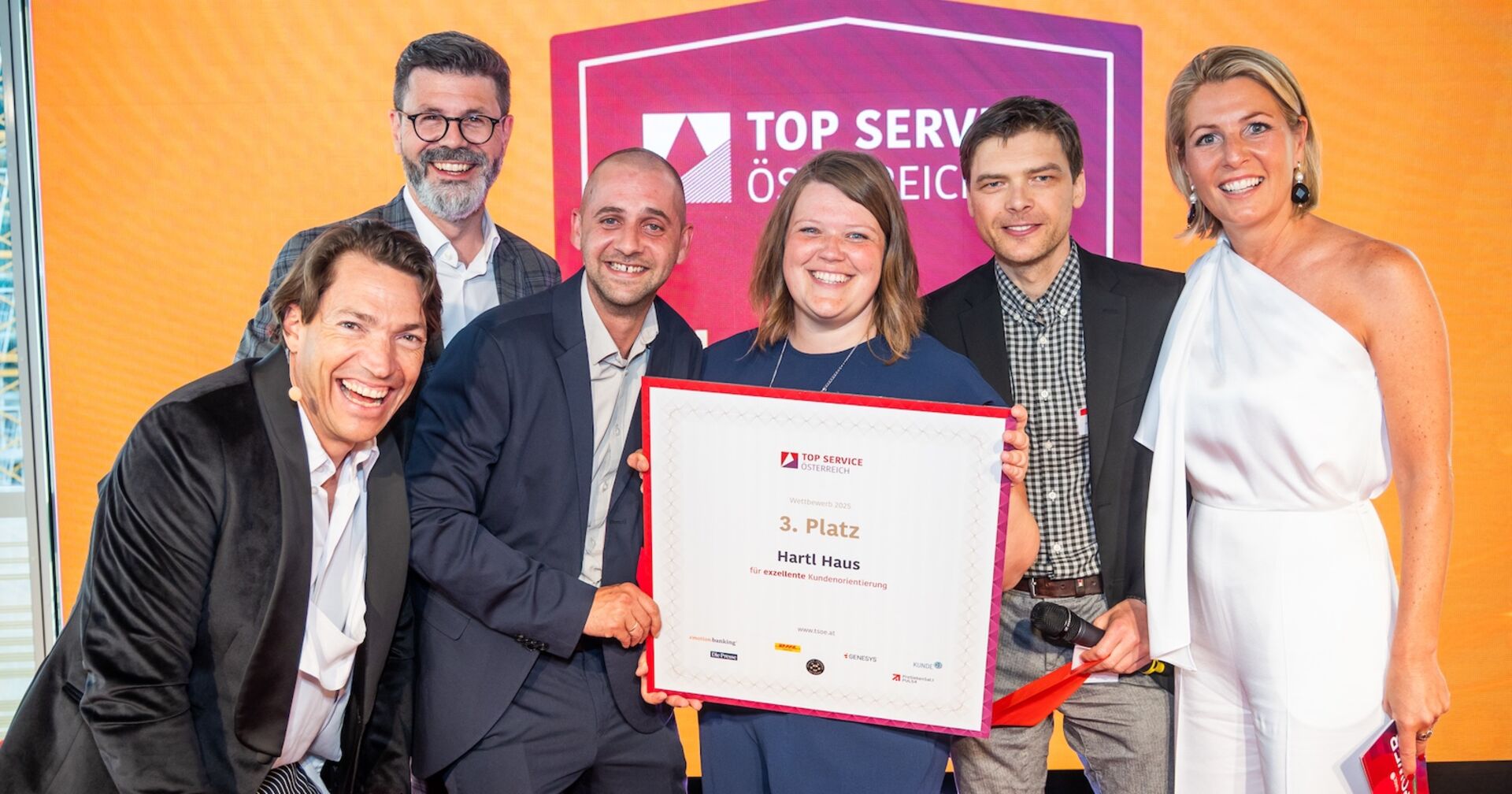 Sechs fröhliche Personen mit Urkunde bei der Top Service Österreich-Verleihung