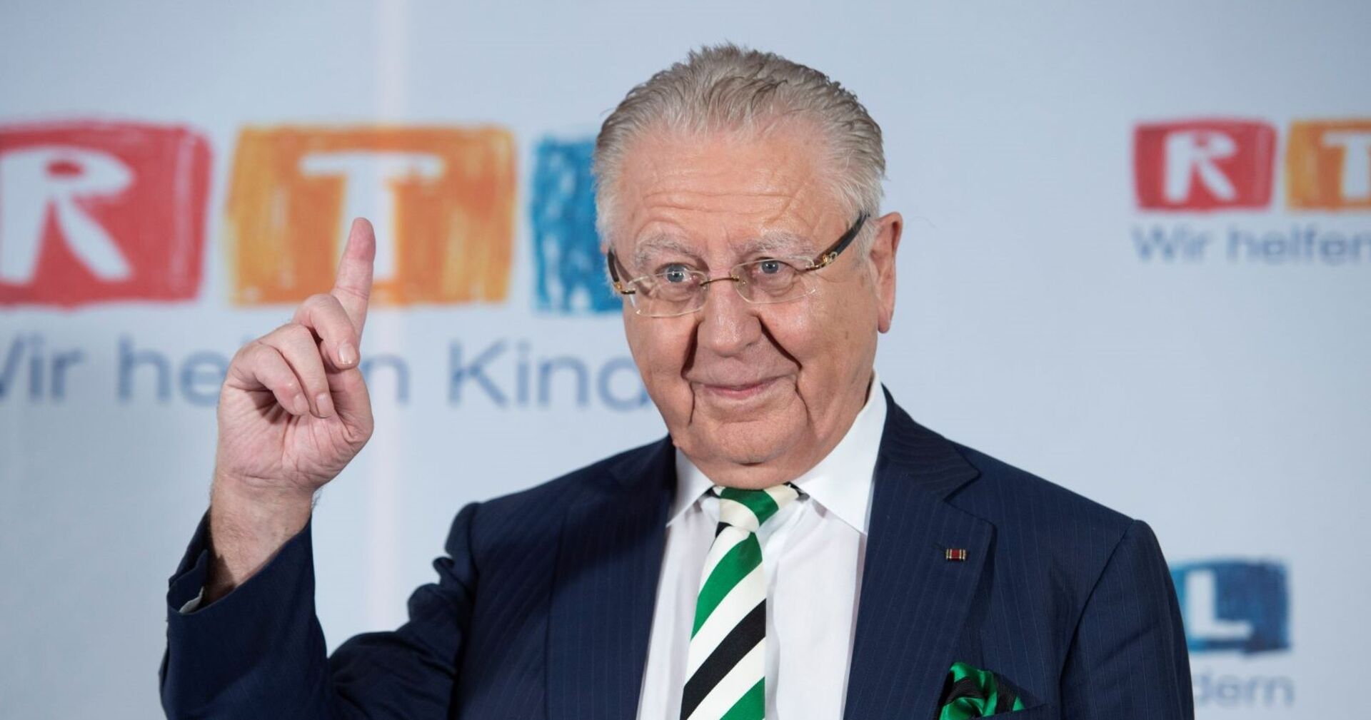 Heinz Horrmann im Anzug mit gestreifter Krawatte und Einstecktuch, hebt mahnend den Finger bei einer Veranstaltung von RTL.