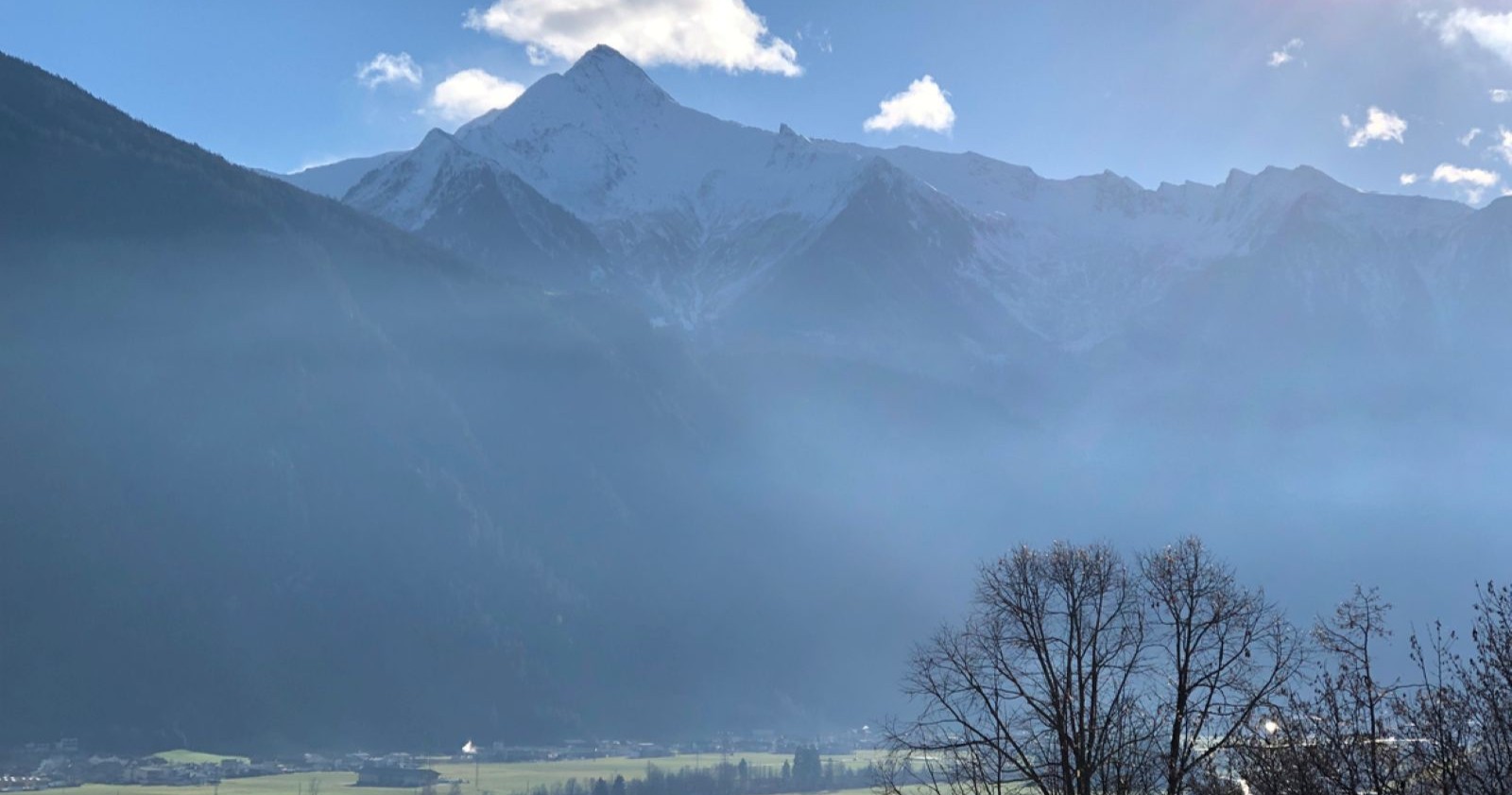 Himmel mit Sonnenschein und leichten Nebelschwaden, Zillertaler Alpen und Bäume
