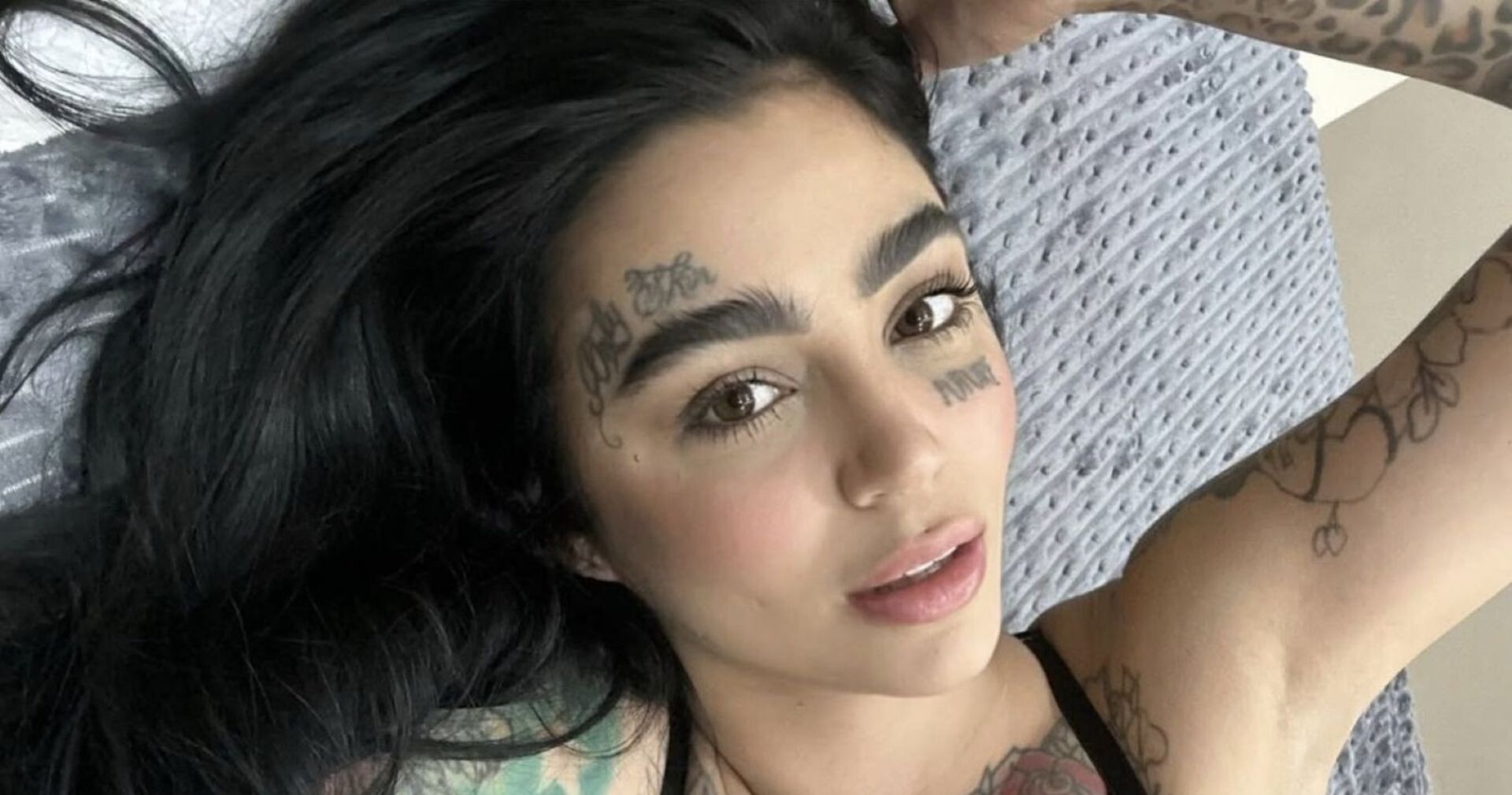 Tätowierte Frau blickt in die Kamera