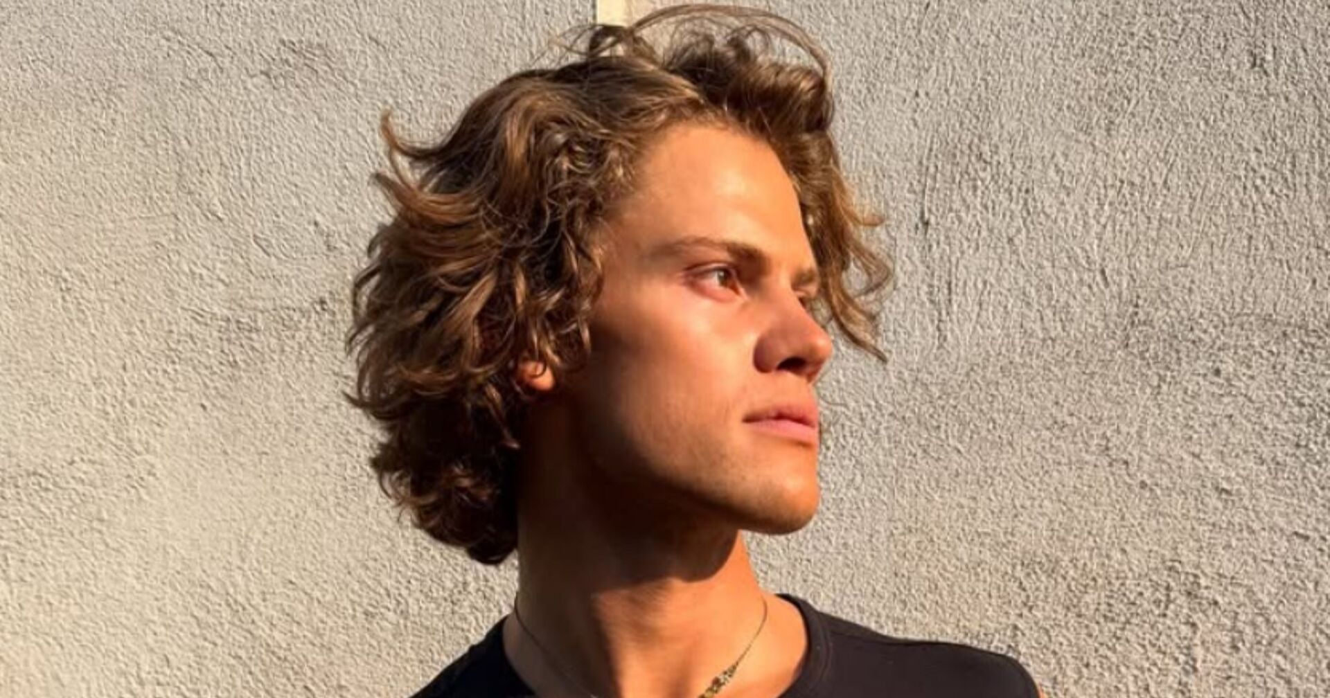 Lucas Braathen schaut zur Seite und steht vor einer Hausmauer