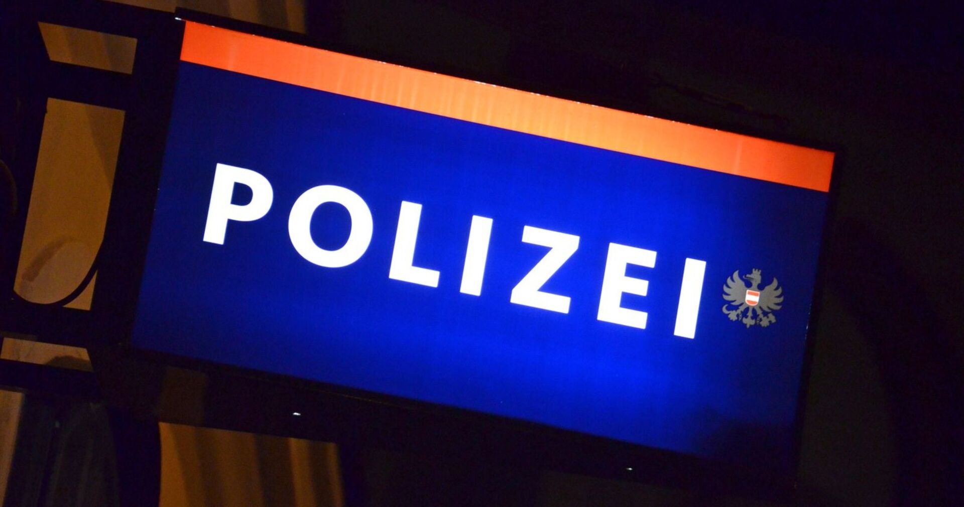 Schild einer Polizeiwache in der Nacht.