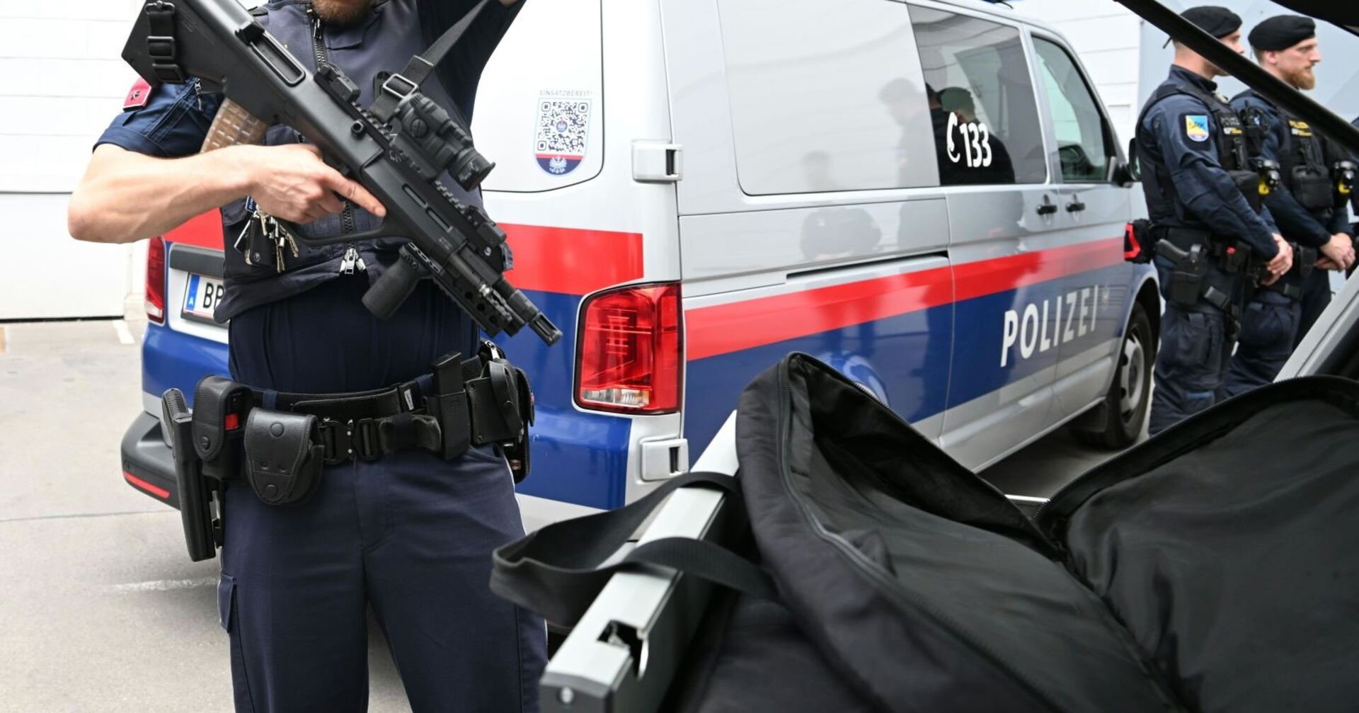 Schwer bewaffnete Polizei beim Einsatz in der Steiermark – Einsatzkräfte der Polizei rücken mit Sturmgewehr und Schutzausrüstung an. Im Hintergrund: ein Polizeibus der Cobra-Einheit. Die Lage an den Schulen in Stainz wurde nach einer Amokdrohung sehr ernst genommen.