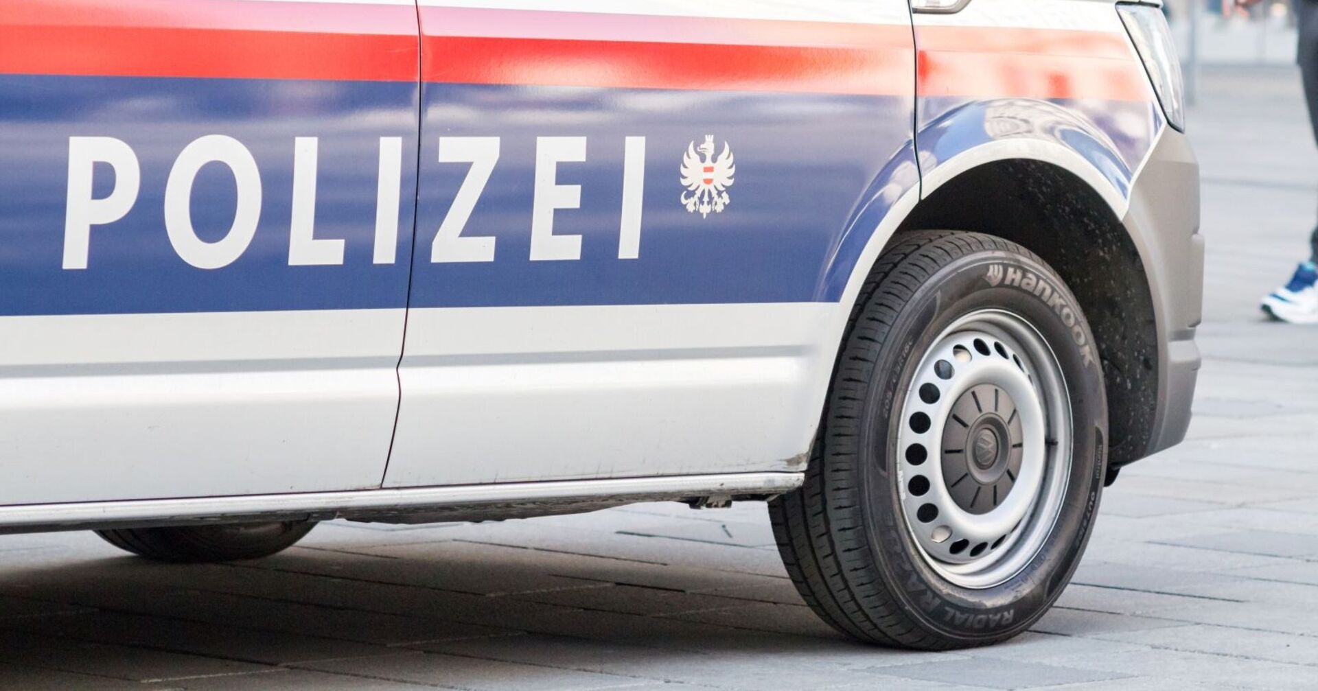 Nahaufnahme eines österreichischen Polizeifahrzeugs, seitlich mit dem Schriftzug „Polizei“, im Einsatz.