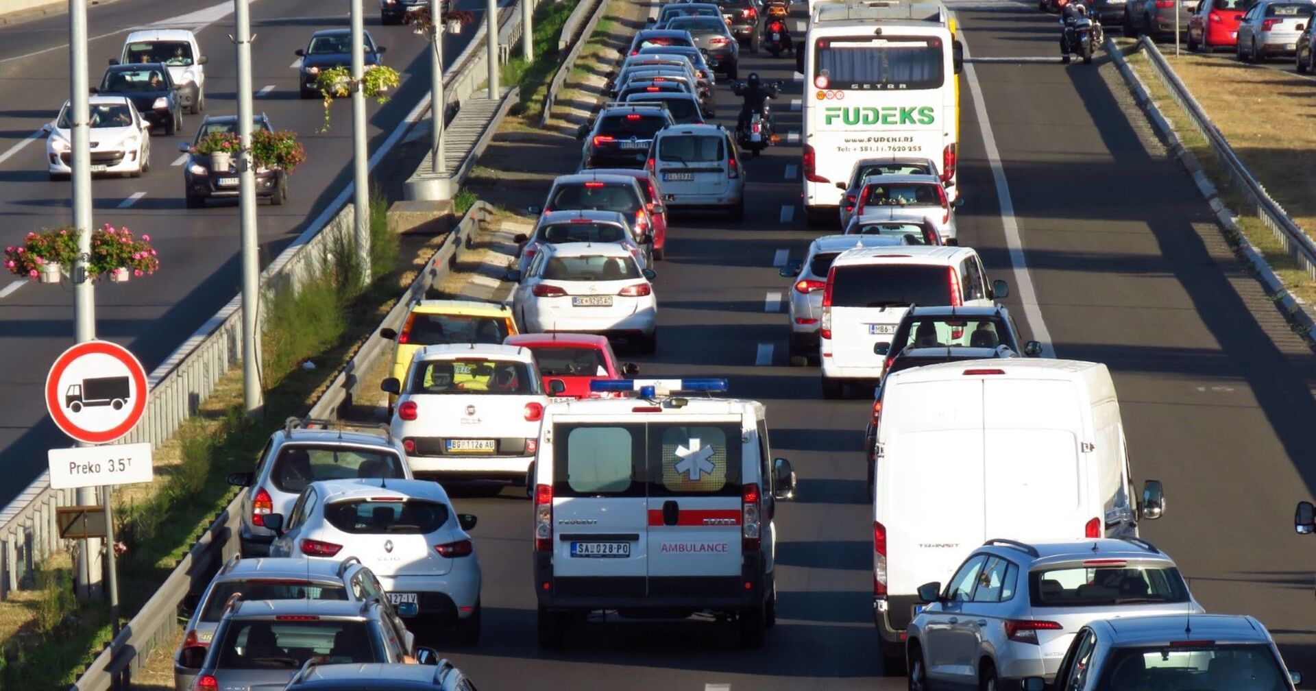 Dichter Verkehr und Stau auf einer mehrspurigen Autobahn in Italien während des Generalstreiks am Feiertag Fronleichnam. Zahlreiche Autos, Busse und ein Rettungswagen stehen still.