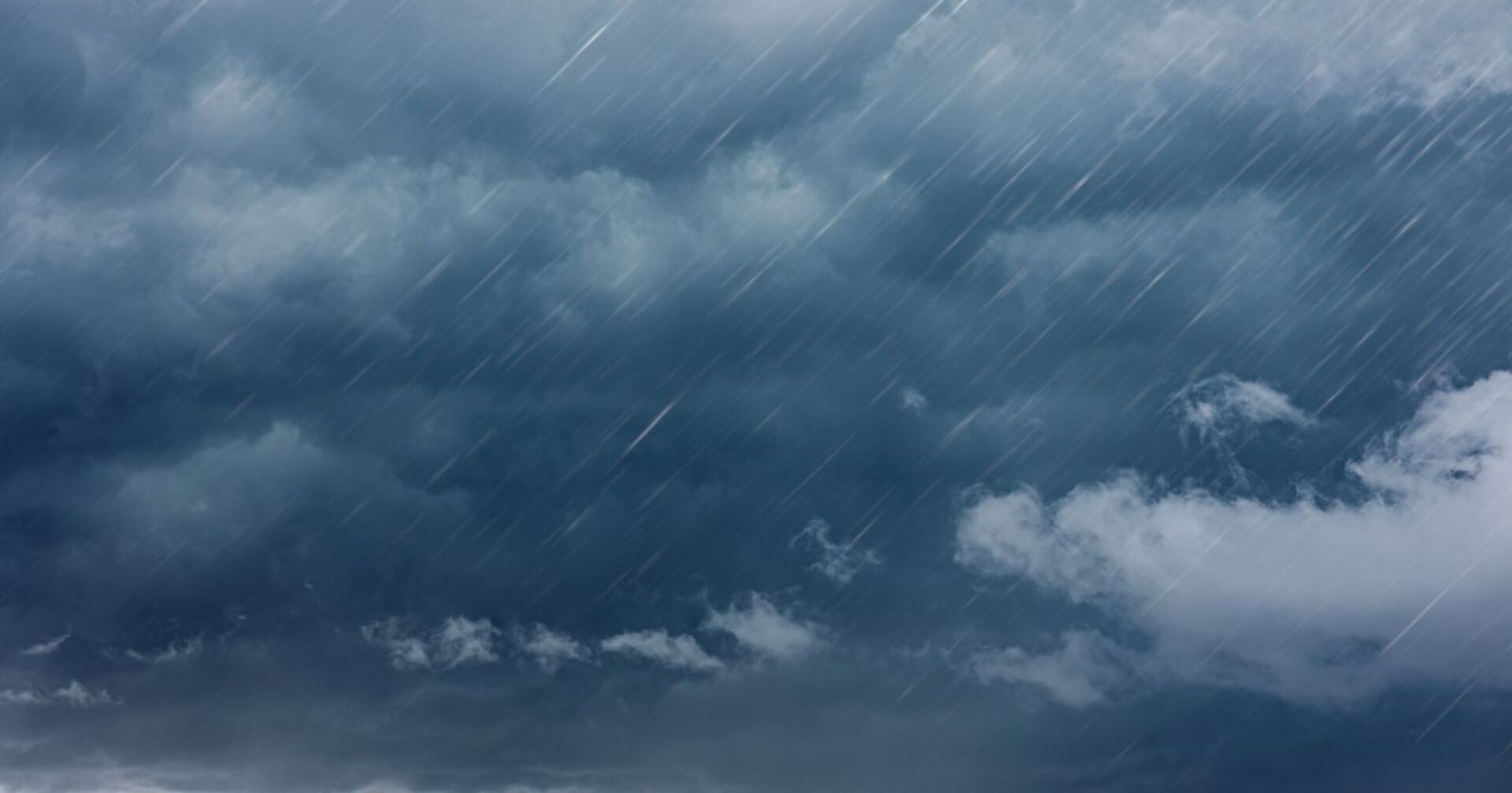Dunkle, wolkenverhangene Himmelslandschaft mit starkem, schräg einfallendem Regen – Symbolbild für ein schweres Gewitter.