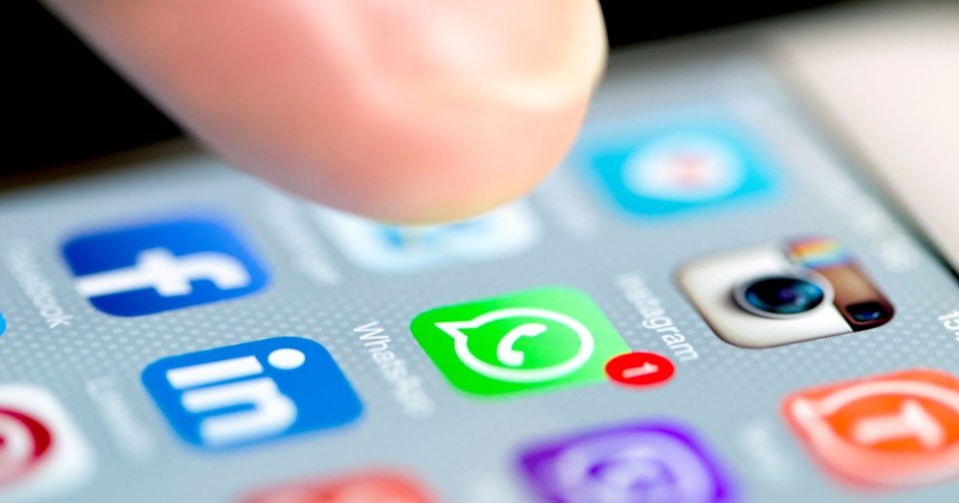 iPhone Display, welches zahlreiche Social Media Apps zeigt, unter andrem WhatsApp