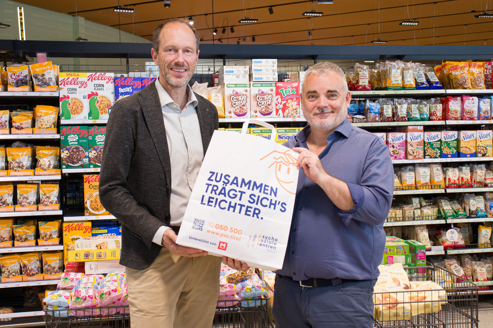 MPREIS Geschäftsführer David Mölk und Geschäftsführer der Psychosozialen Zentren Tirol Michael Wolf präsentieren die neue Tragetasche. (v.l.)