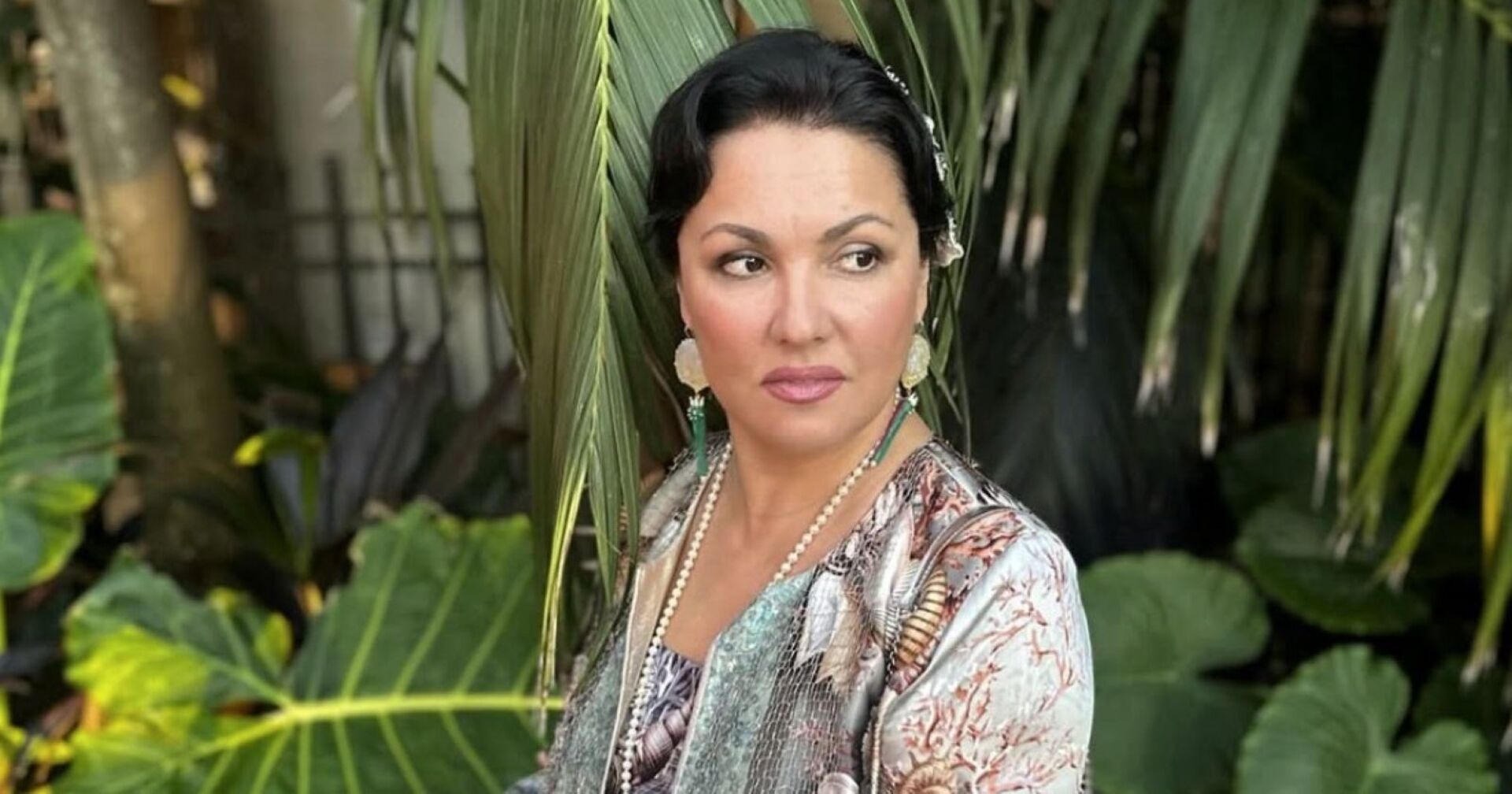 Anna Netrebko mit Pflanzen im Hintergrund