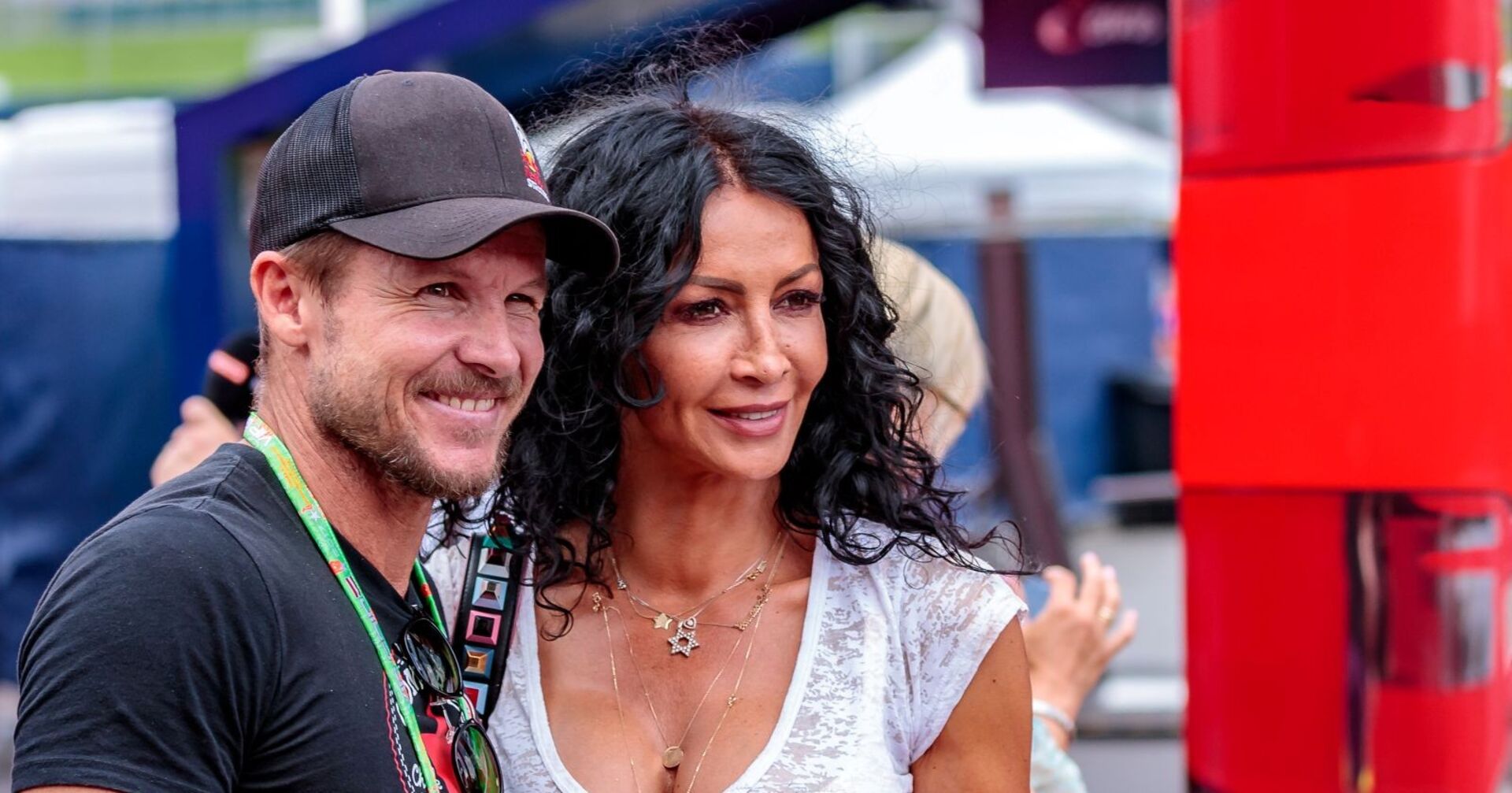 Felix Baumgartner lächelt neben Mihaela Schwartzenberg, beide stehen eng beieinander bei einem Event im Freien.