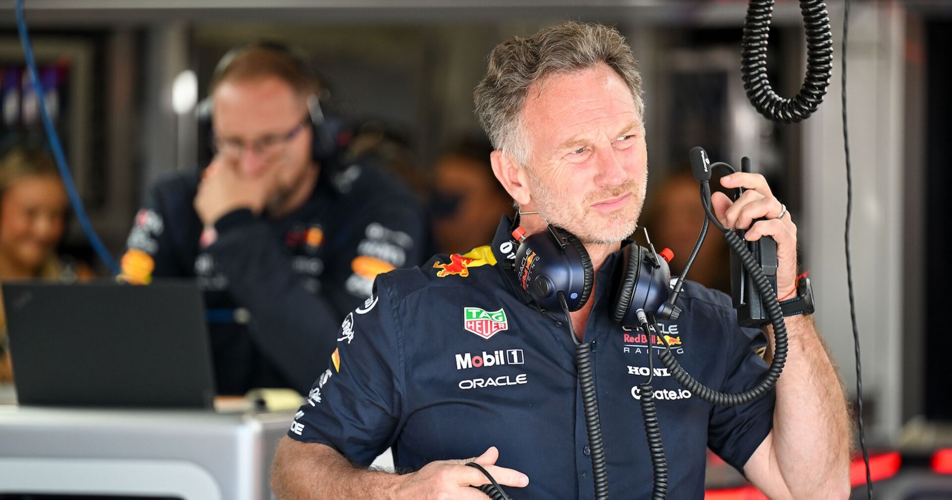 Christian Horner mit Headset in der Red-Bull-Garage, leicht nachdenklicher Blick; Ex-Teamchef von Red Bull Racing, dessen Entlassung hohe Kosten für den Rennstall verursachen könnte.