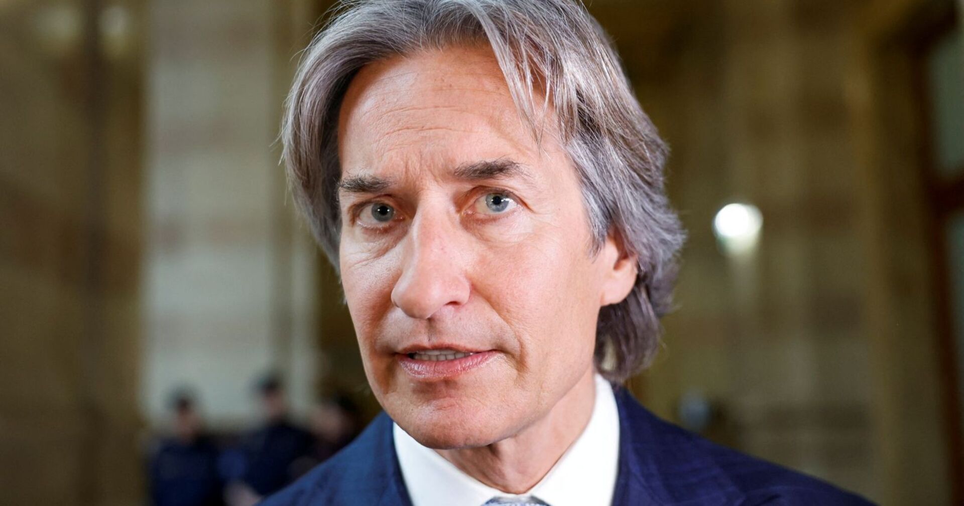 Porträt von Karl-Heinz Grasser im Anzug, aufgenommen in einem Gerichtsgebäude. Der ehemalige österreichische Finanzminister blickt ernst in die Kamera.