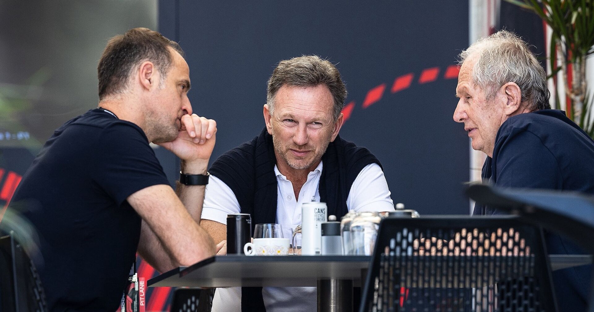 Drei Red-Bull-Verantwortliche sitzen an einem Tisch und führen ein intensives Gespräch, darunter Teamchef Christian Horner und Motorsport-Berater Helmut Marko.