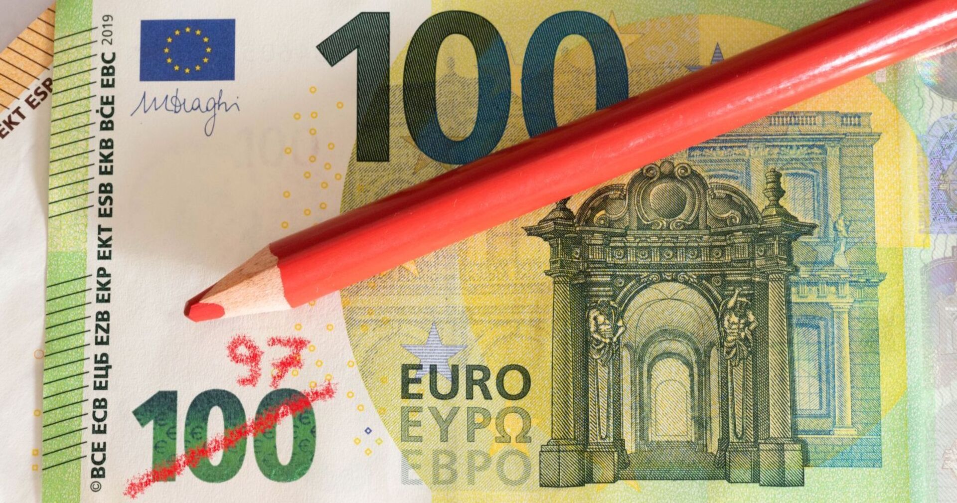 100-Euro-Schein mit rotem Buntstift durchgestrichen und handschriftlich zu „97“ korrigiert – symbolisiert Kaufkraftverlust durch Inflation.