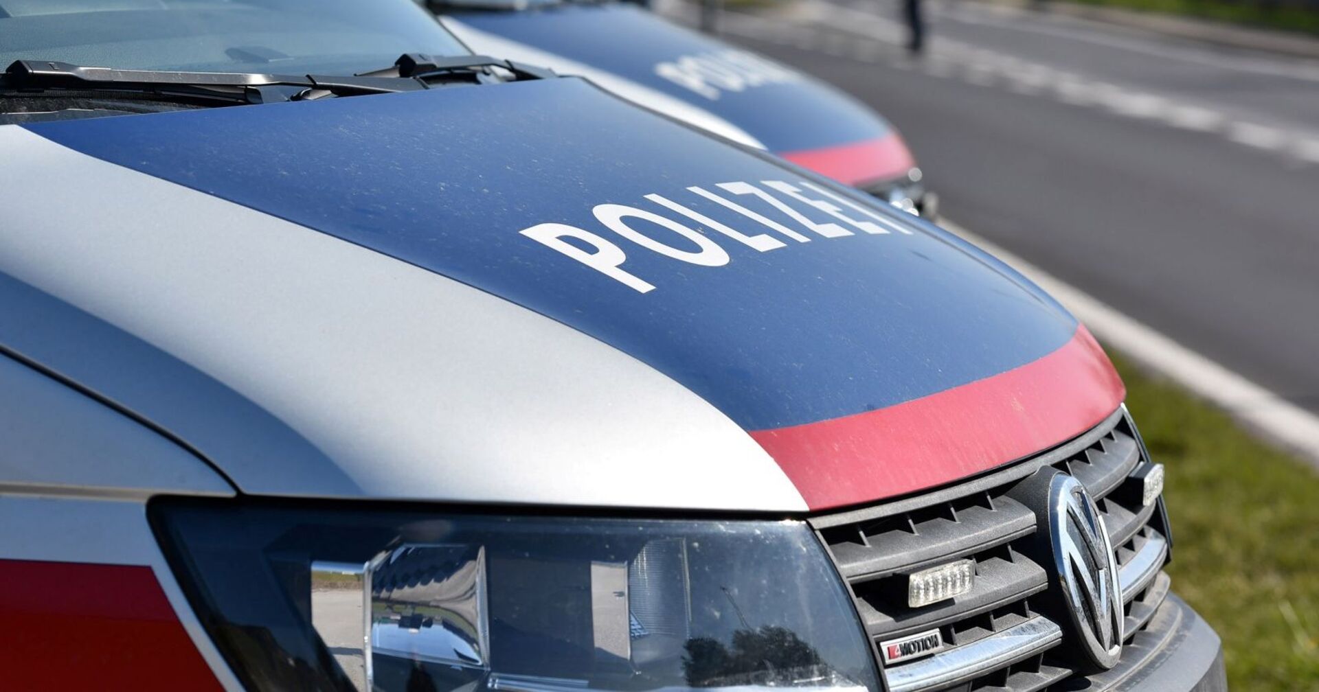 Zwei Minibusse des Modells VW-Transporter der Polizei auf einer Straße am Tag