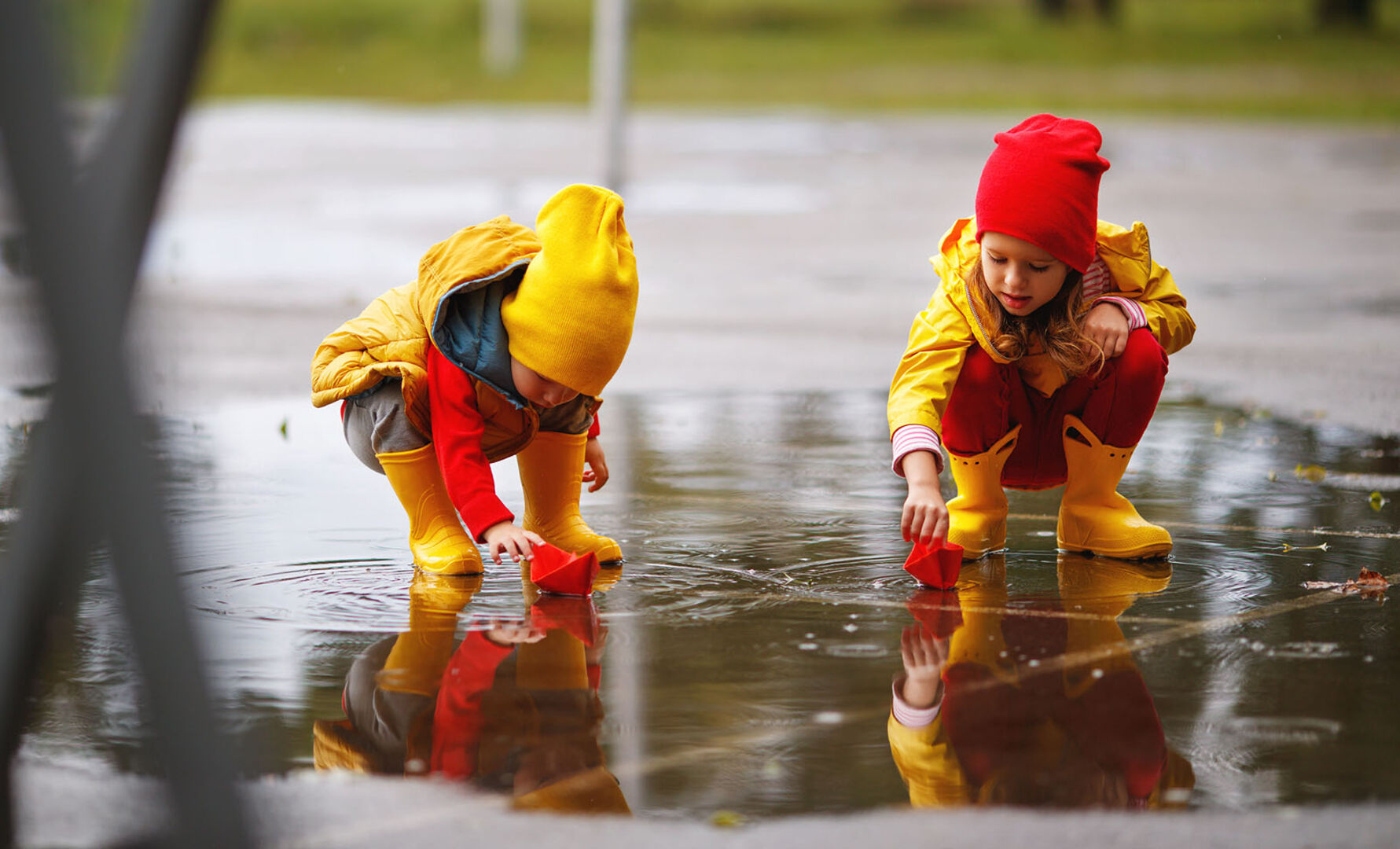 Kinder spielen zusammen im Regen | Credit: iStock.com/evgenyatamanenko