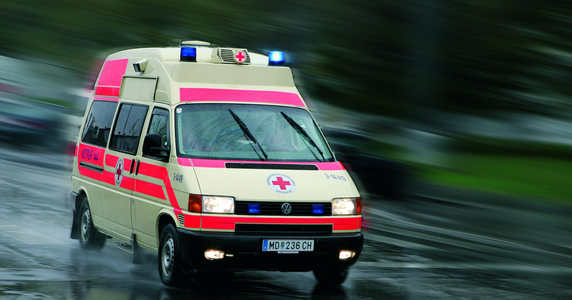 Rettungswagen des Roten Kreuz Österreich auf einer Fahrt im Regen