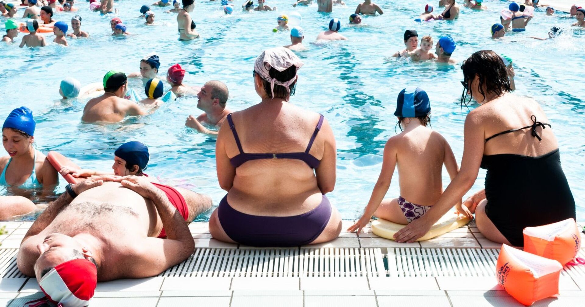 Becken voller Menschen an einem Sommertag in einem Freibad