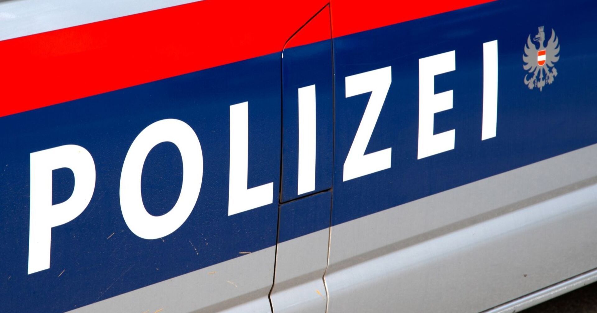 Großaufnahme der Aufschrift &quot;Polizei&quot; auf einem Einsatzwagen.