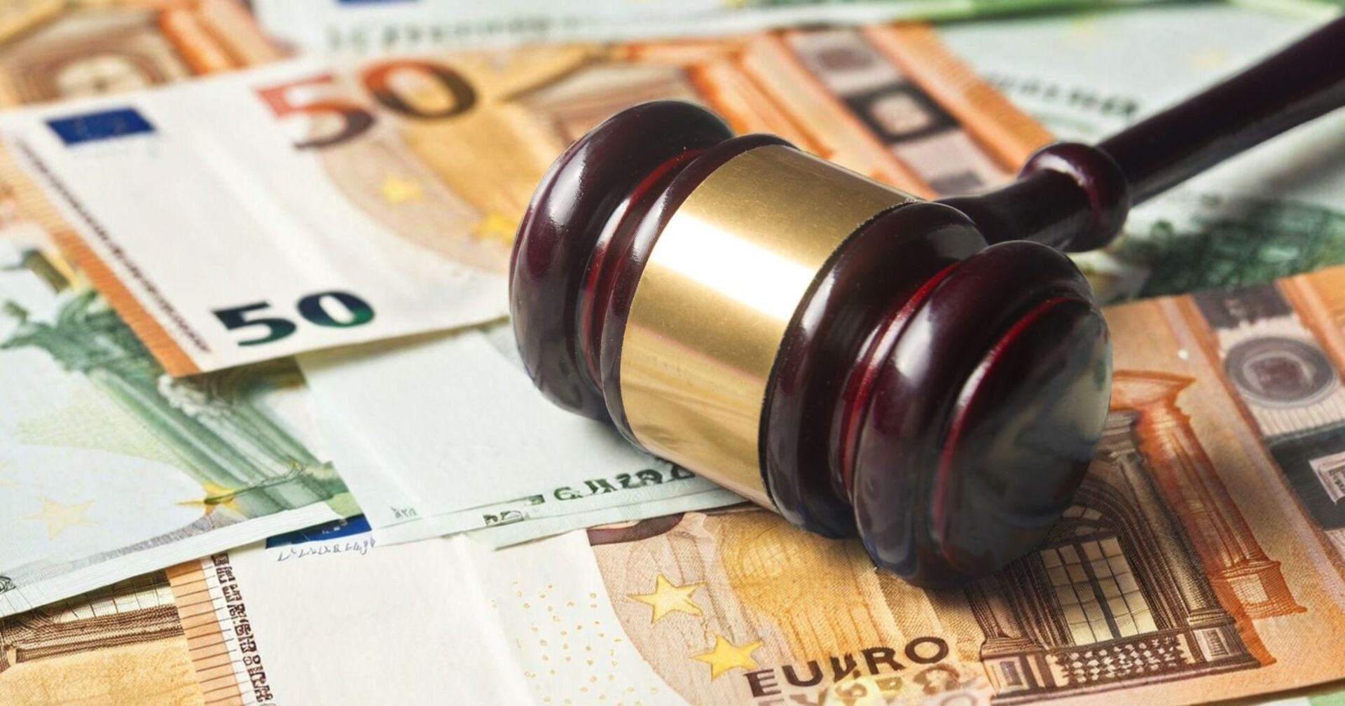 Hammer auf einem Bett von 50 und 100 Euro-Banknoten liegend