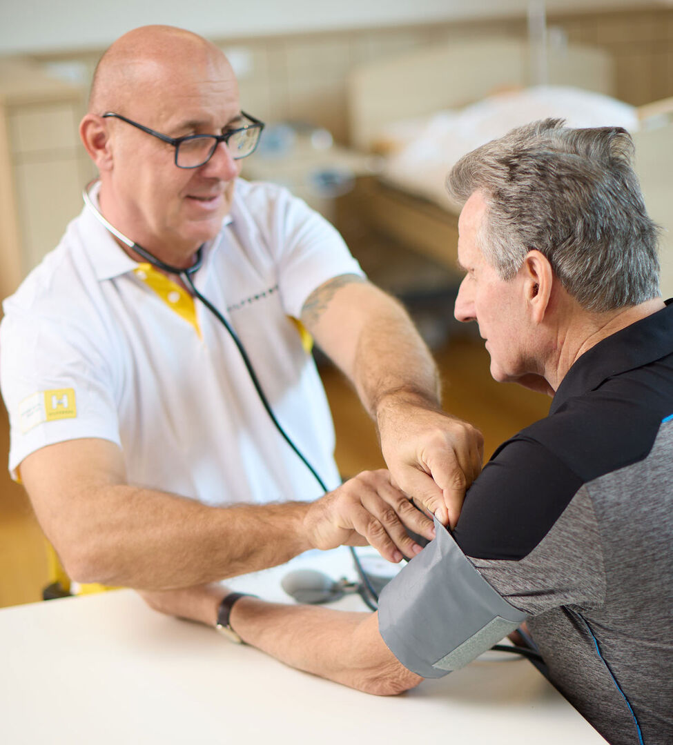 Pfleger misst den Blutdruck eines Pensionisten | Credit: Hilfswerk Salzburg/Hechenberger