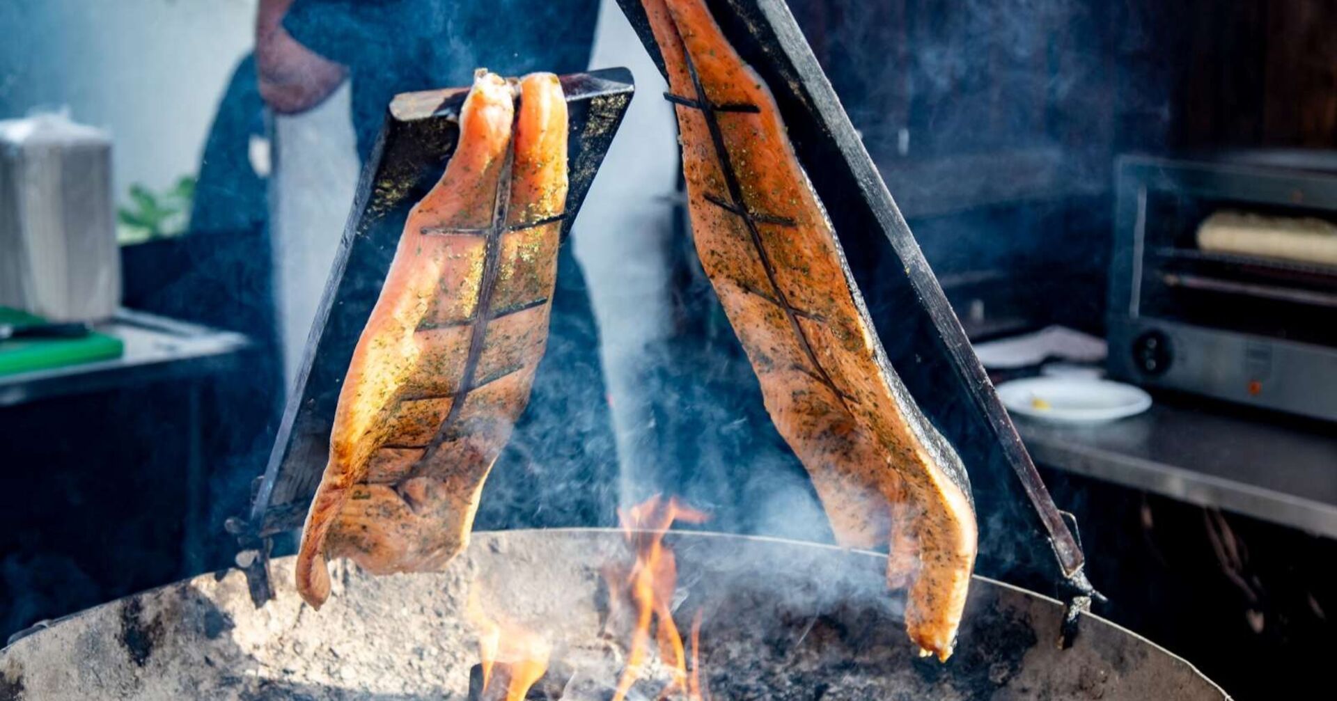 Zwei Stücke gewürzter Lachs werden traditionell als Flammlachs über offenem Feuer gegart.