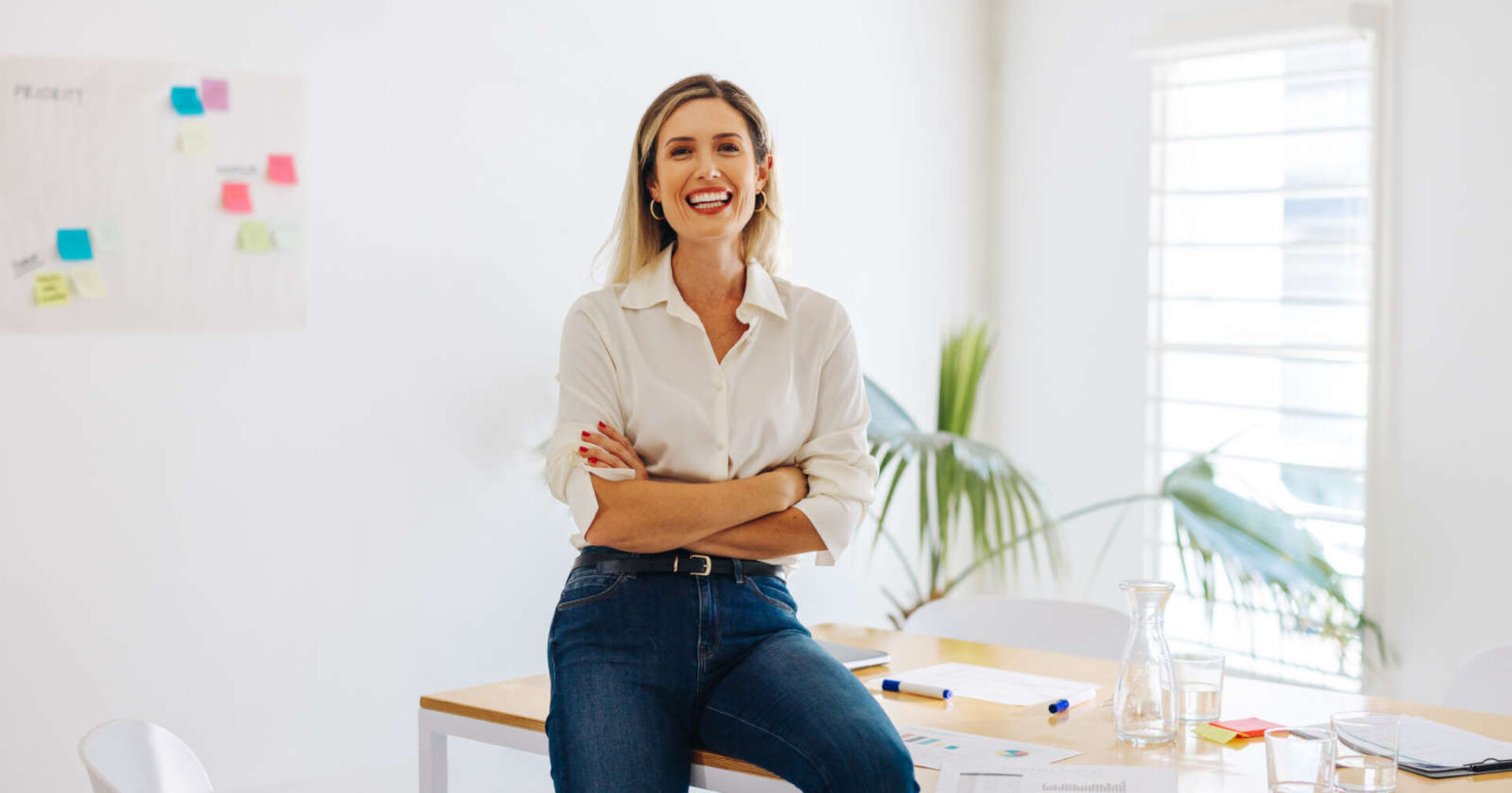 Frau lächelt und sitzt auf einem Tisch