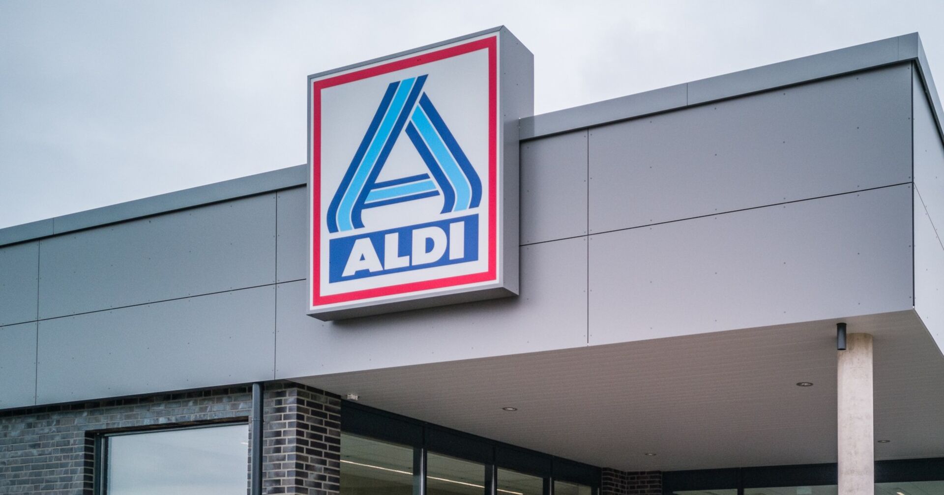 Aldi-Filiale mit prominentem Logo an der Fassade eines modernen Gebäudes.