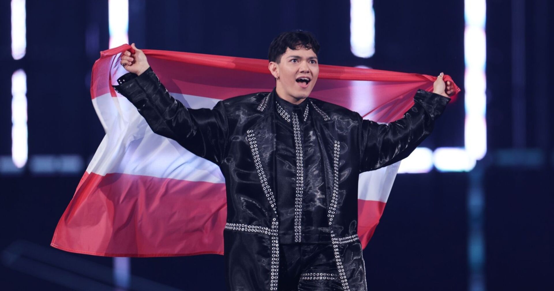 ESC-Sieger JJ hält die österreichische Flagge hinter sich und jubelt auf der Bühne beim Eurovision Song Contest 2025.