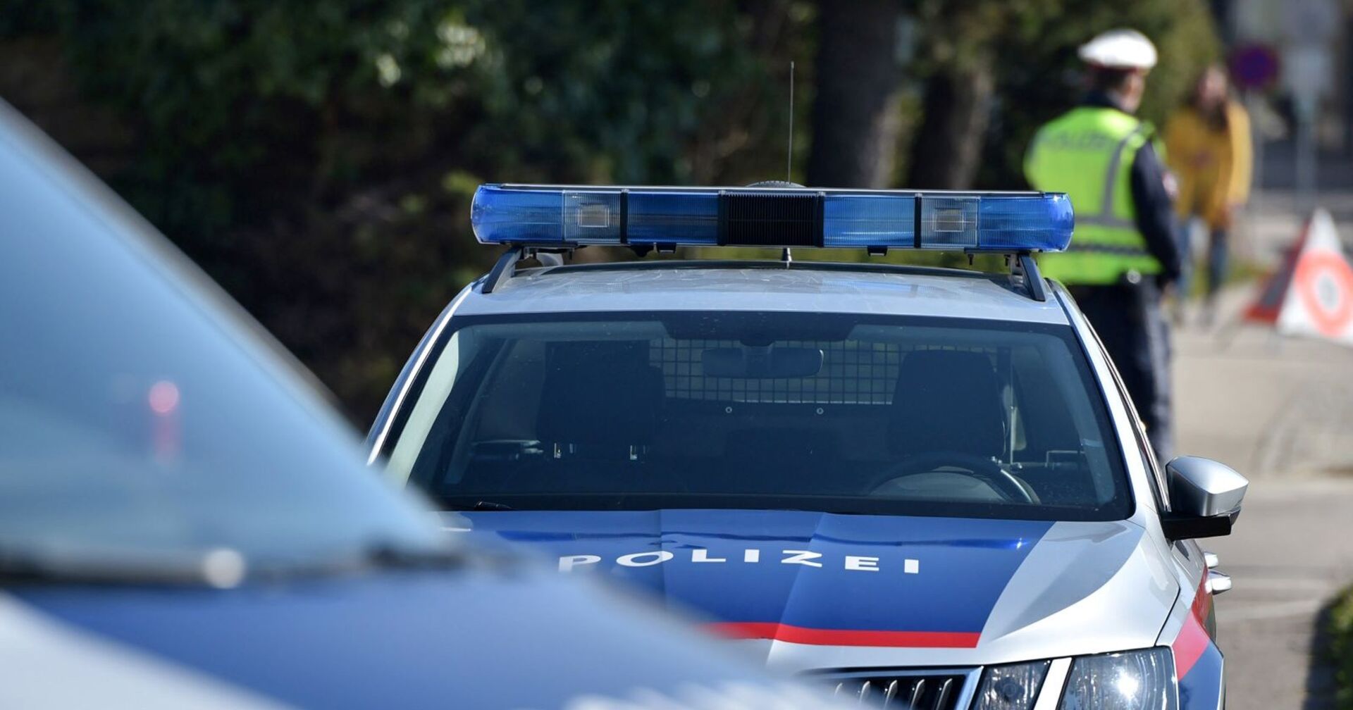 Polizeiauto und ein Polizist.